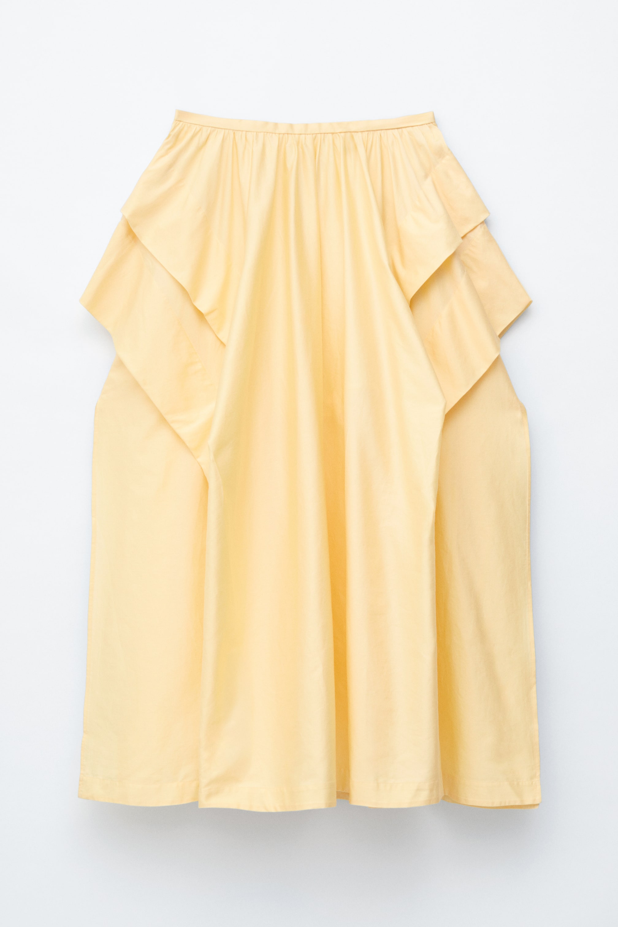 Nagyobb kép megtekintése: Egy sárga midi szoknya látható laposan, elölről nézve. A deréknál ráncolásokkal és széles, varrott hajtásokkal az oldalakon, amelyek dús sziluettet hoznak létre.