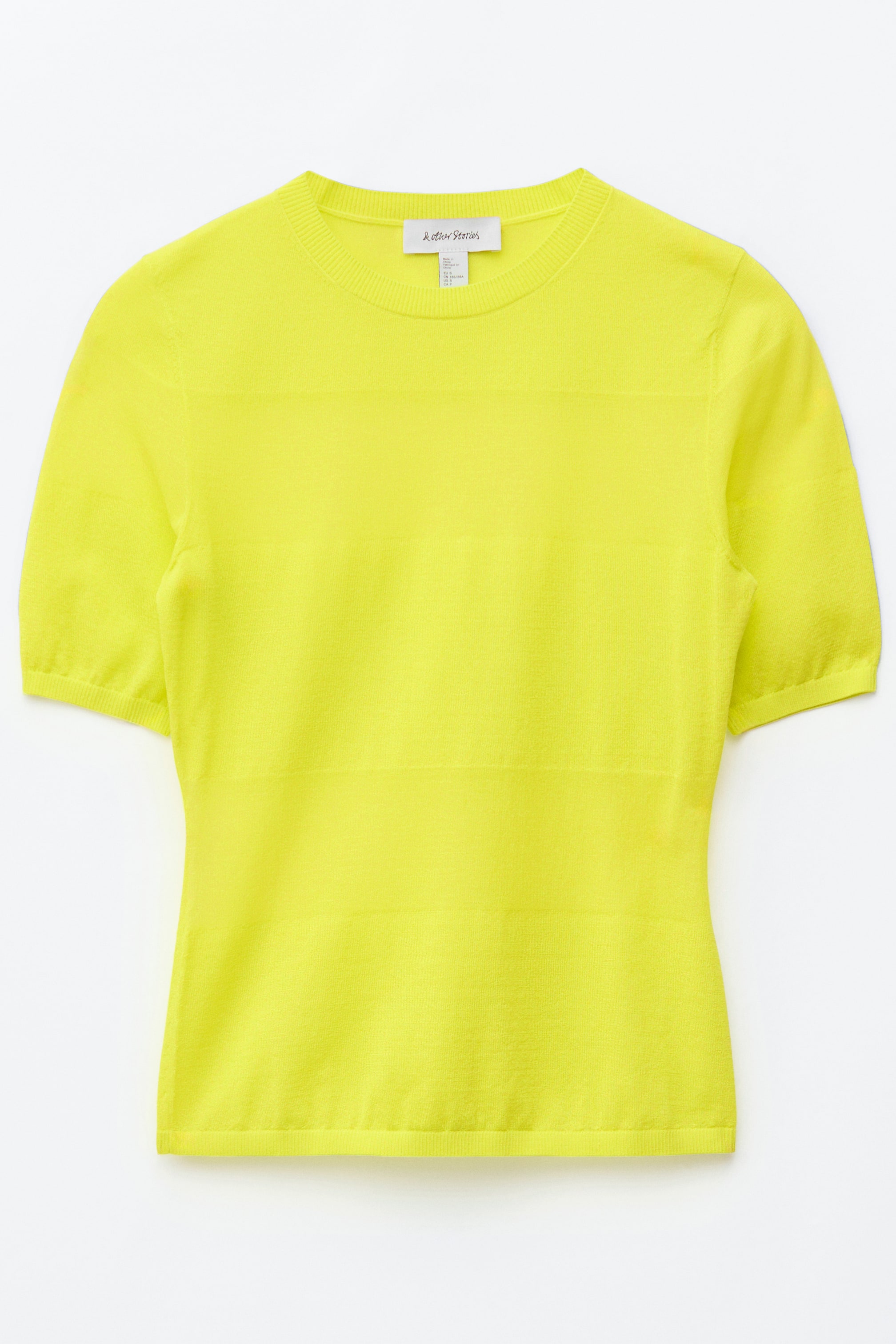 Vezi imaginea mai mare: Un tricou galben aprins din tricot fin este afișat din față, având un guler clasic rotund și mâneci scurte. Prezintă margini subtile cu nervuri pe guler, manșetele mânecilor și tiv, cu modele fine de tricot orizontal vizibile pe întreaga suprafață.