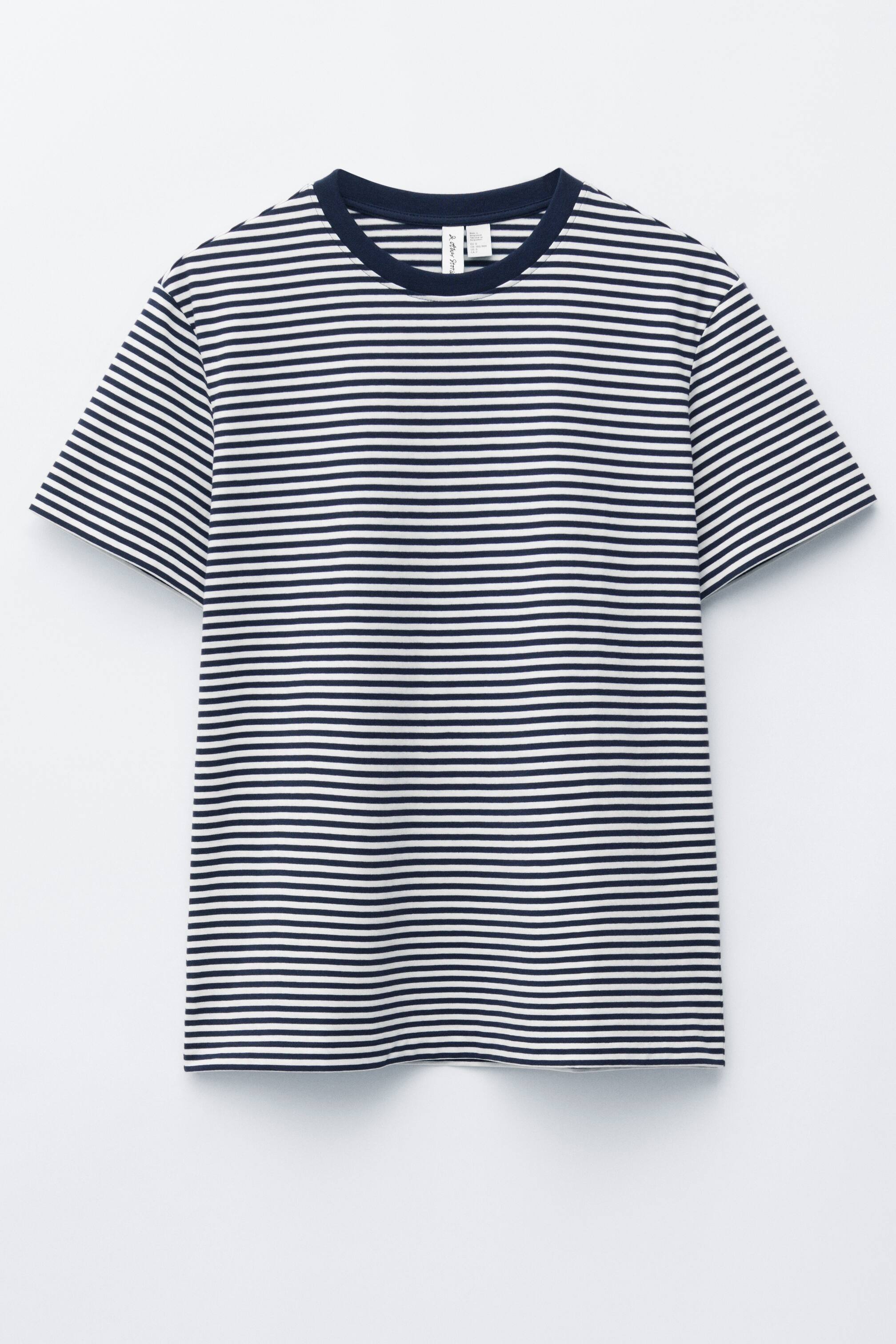 Se større billede: En T-shirt viser sin forside med vandrette marineblå og hvide striber, en marineblå ribbet rund halsudskæring, korte ærmer og en lige silhuet.