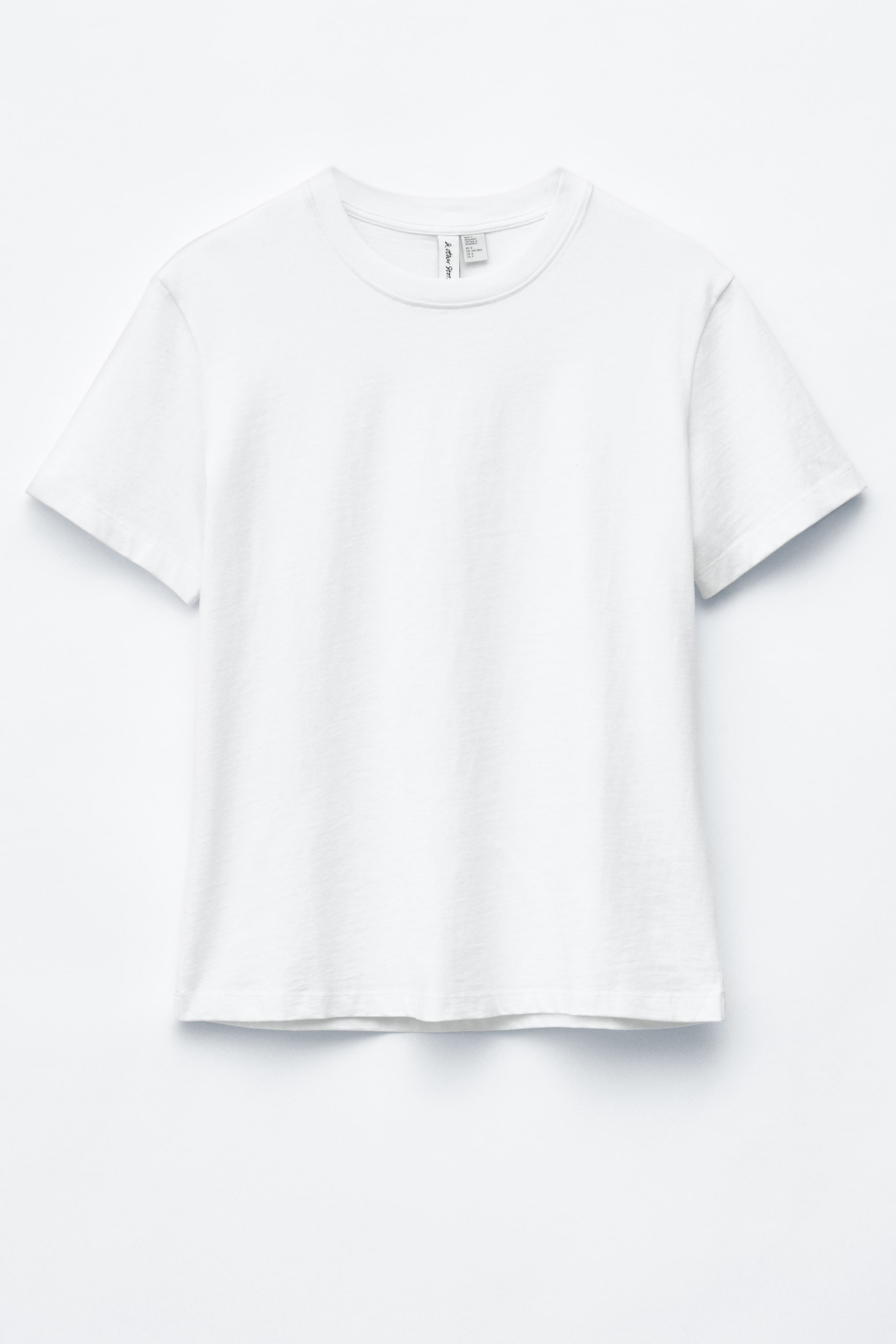 Se større billede: En hvid t-shirt præsenteres forfra med en ribbet rund halsudskæring og korte ærmer, der viser en lige, regulær pasform silhuet.