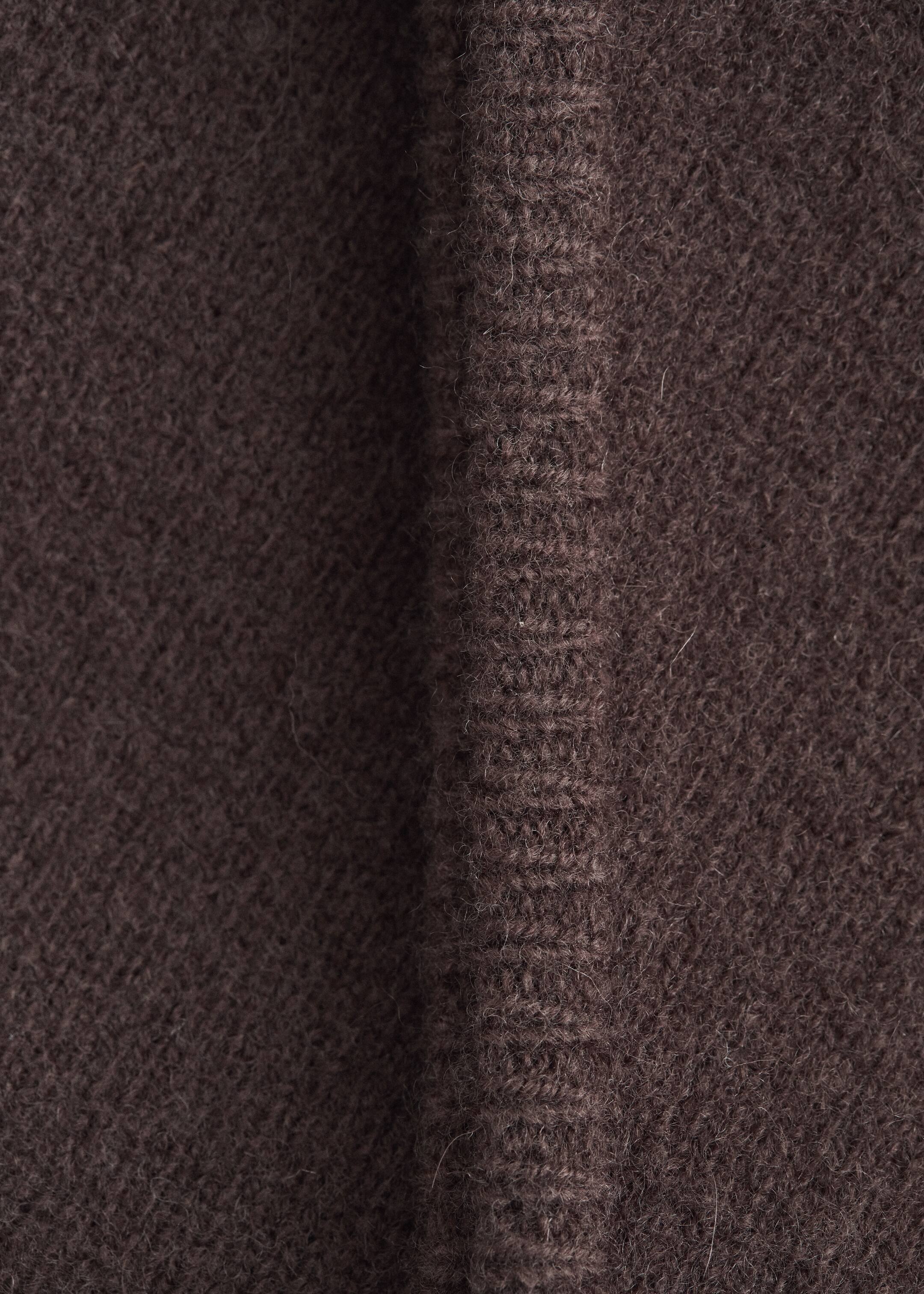 Agrandir l'image: Ce foulard triangulaire en laine brun foncé présente sa texture douce et duveteuse ainsi qu'une couture verticale avec un point de surjet délicat ton sur ton.