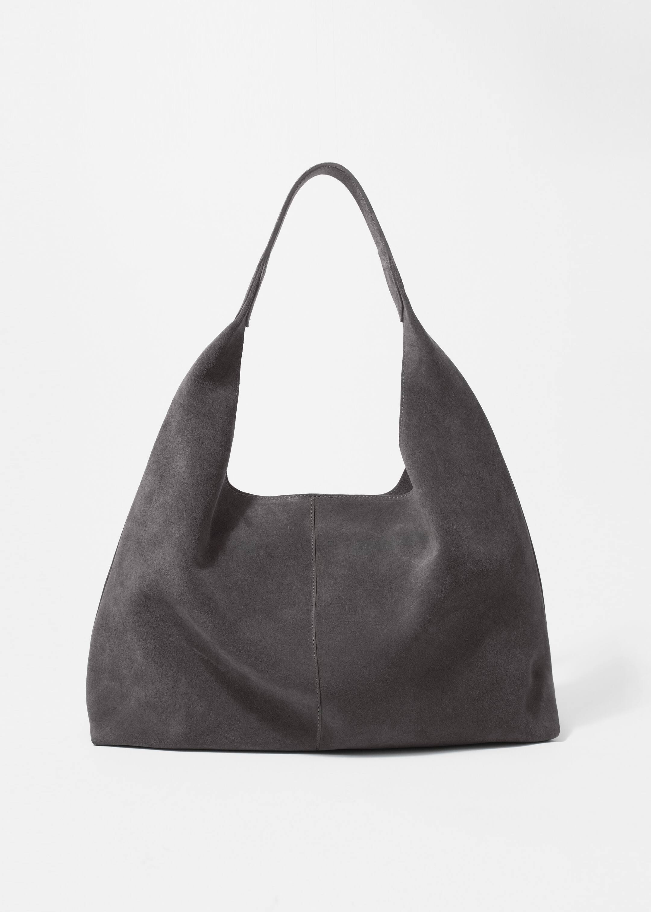 Grösseres Bild ansehen: Eine dunkelgraue Wildleder-Tote-Bag wird von vorne gezeigt, mit mattem Finish, einem einzelnen integrierten Schulterriemen und einer sichtbaren vertikalen Naht, die in der Mitte verläuft.
