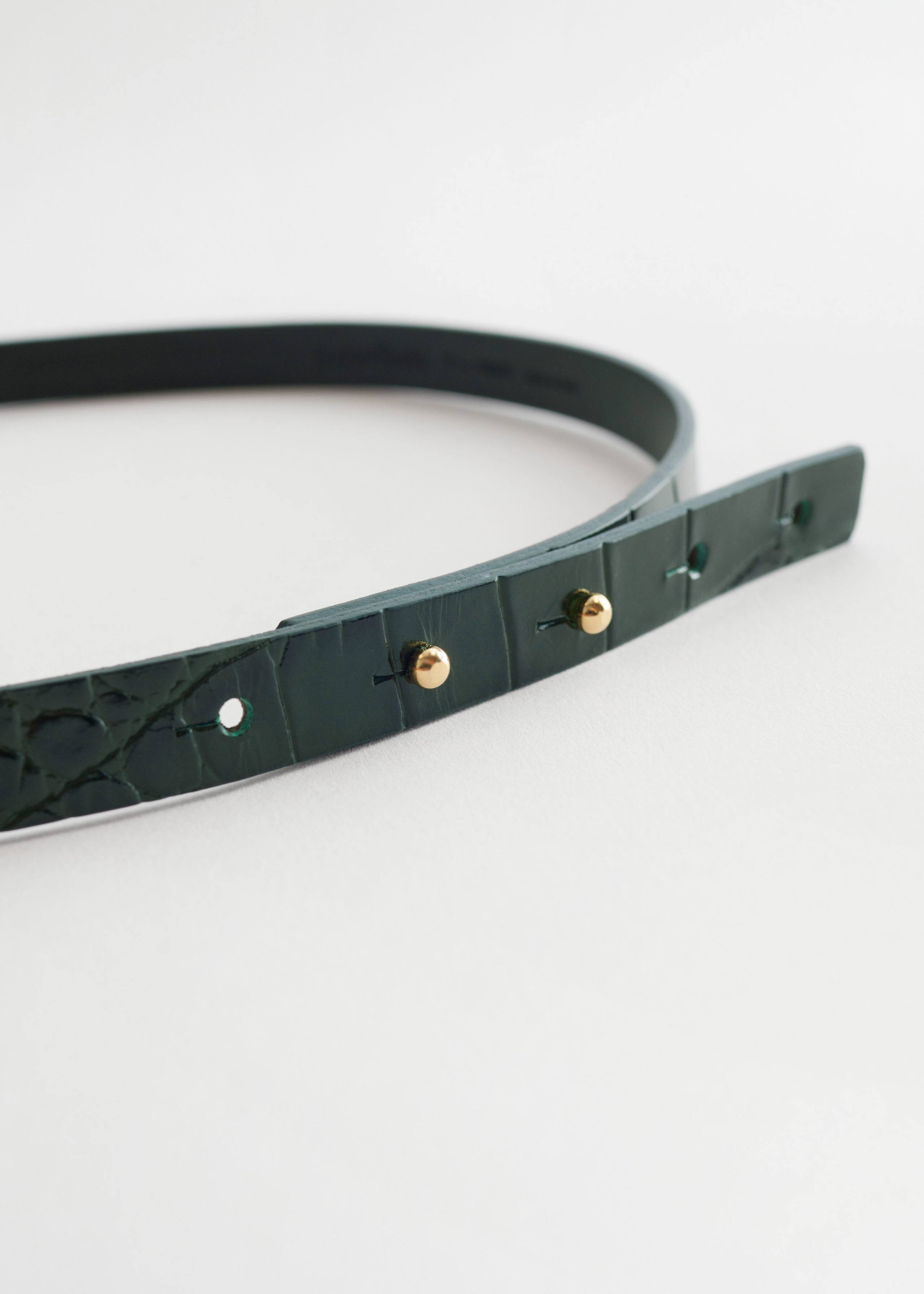 CrocLeatherBuckleBelt - {{variantName}} - Detalle descriptivo