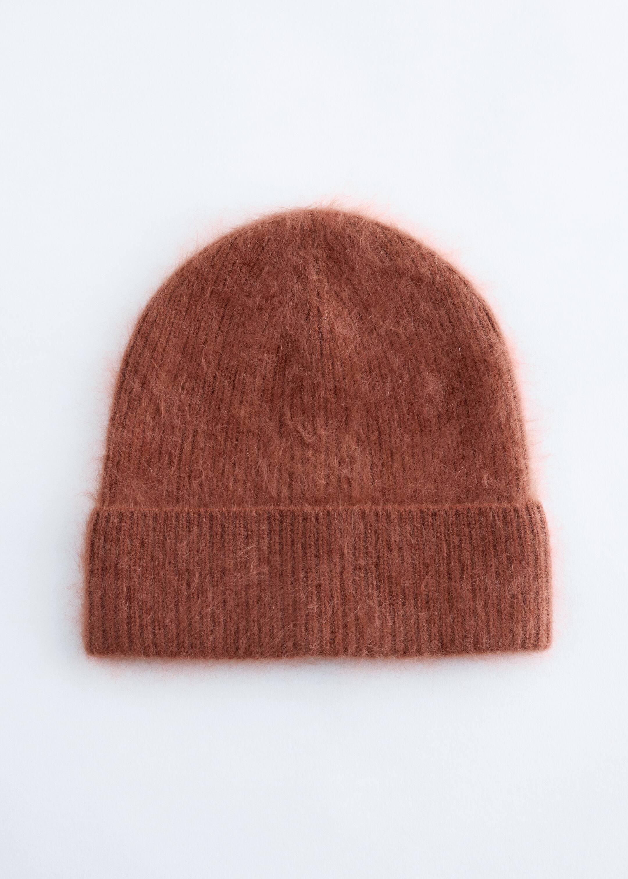 Agrandir l'image: Un bonnet brun-rouge affiche une texture brossée et duveteuse ainsi qu'un large revers côtelé sur le devant.