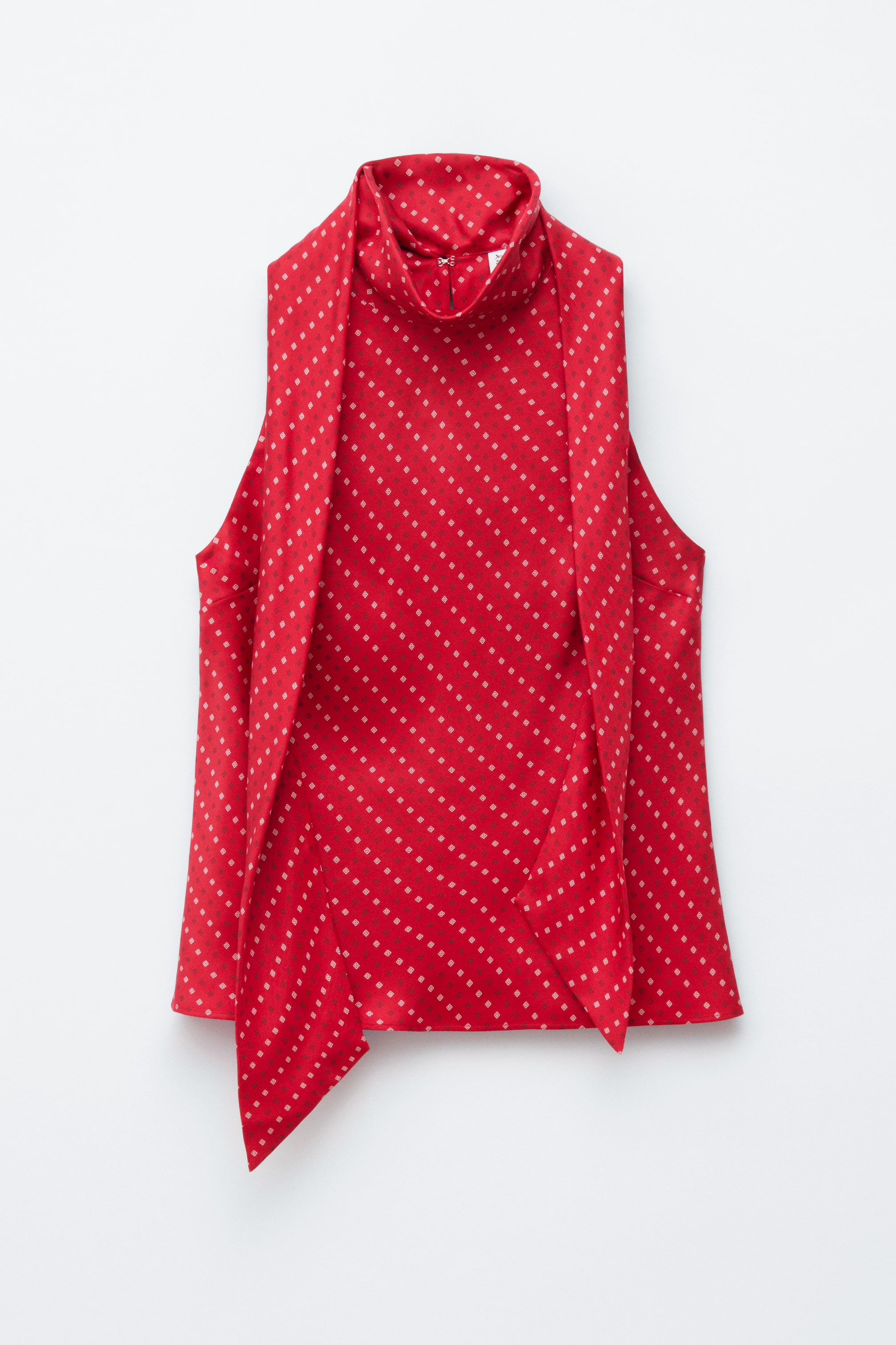 Преглед на по-голямо изображение: Предната част на червен топ без ръкави е с графичен принт на малки диамантени форми, подредени в диагонални редове. Дизайнът включва интегриран детайл с шал, който се простира от високата яка, и отвор с кука и око за закопчаване на гърба на врата.