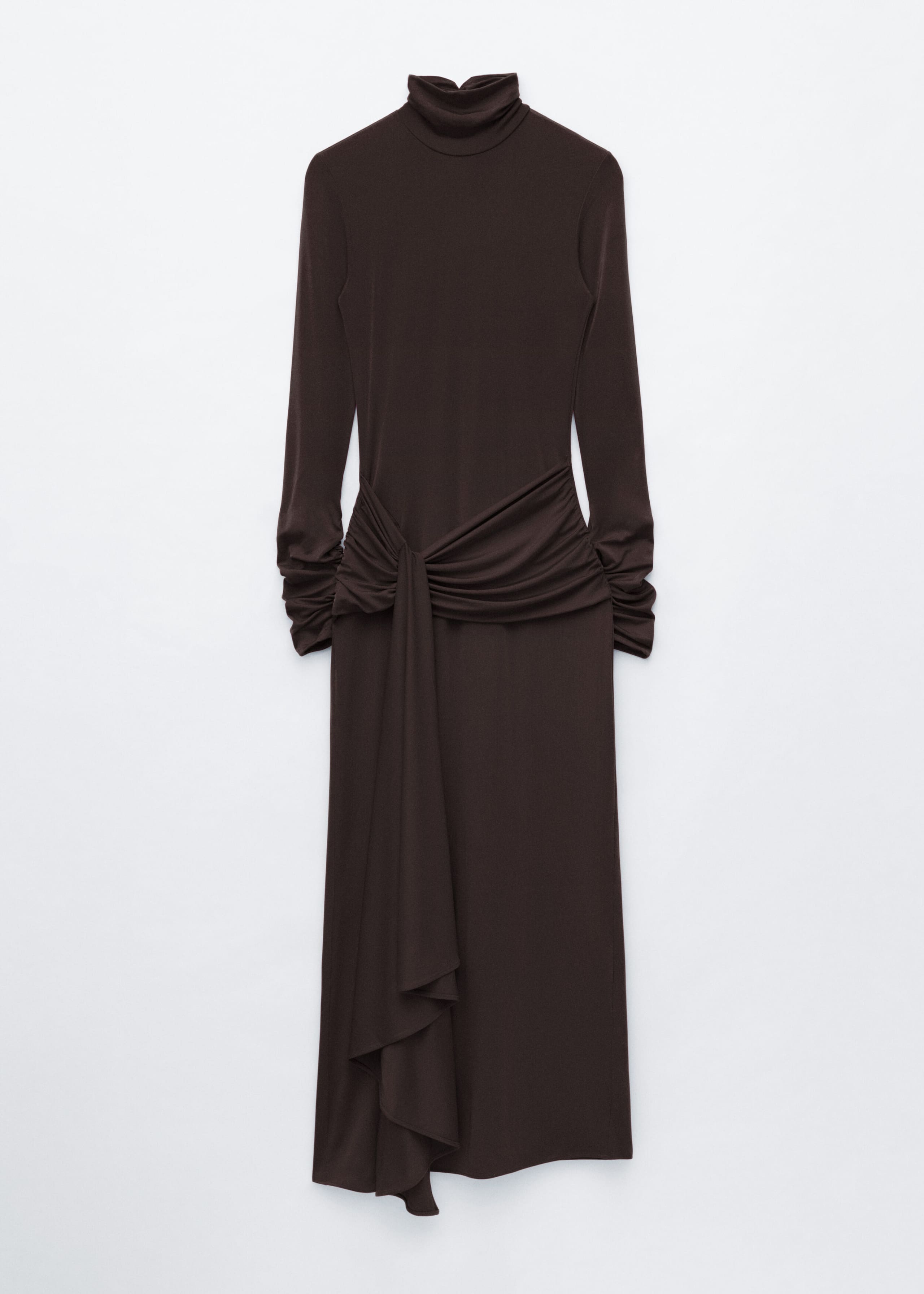 A dark brown jersey maxi dress is hanging front-facing, showcasing a slim-fit silhouette with long sleeves and a double-layer mock neck. The waist is detailed with a draped tie that creates gathered folds and a fluid fabric panel cascading down the front of the skirt.