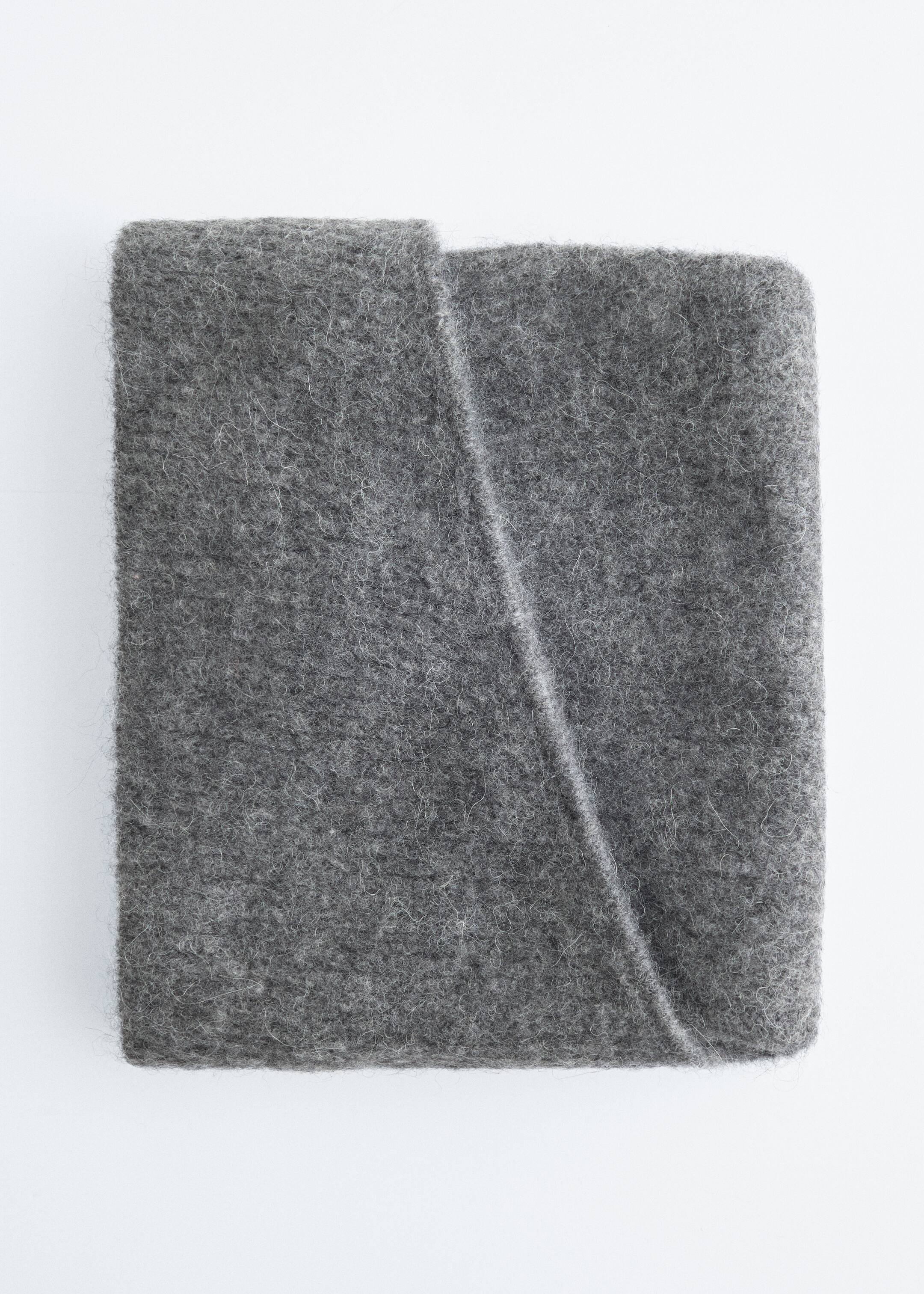 Größeres Bild anzeigen: Ein grauer Filzstoff wird flach gefaltet präsentiert, mit einer markanten diagonalen Falte, die sich über seine Oberfläche bildet. Das dicke Material zeigt eine weiche, flauschige Textur mit sichtbaren Fasern.
