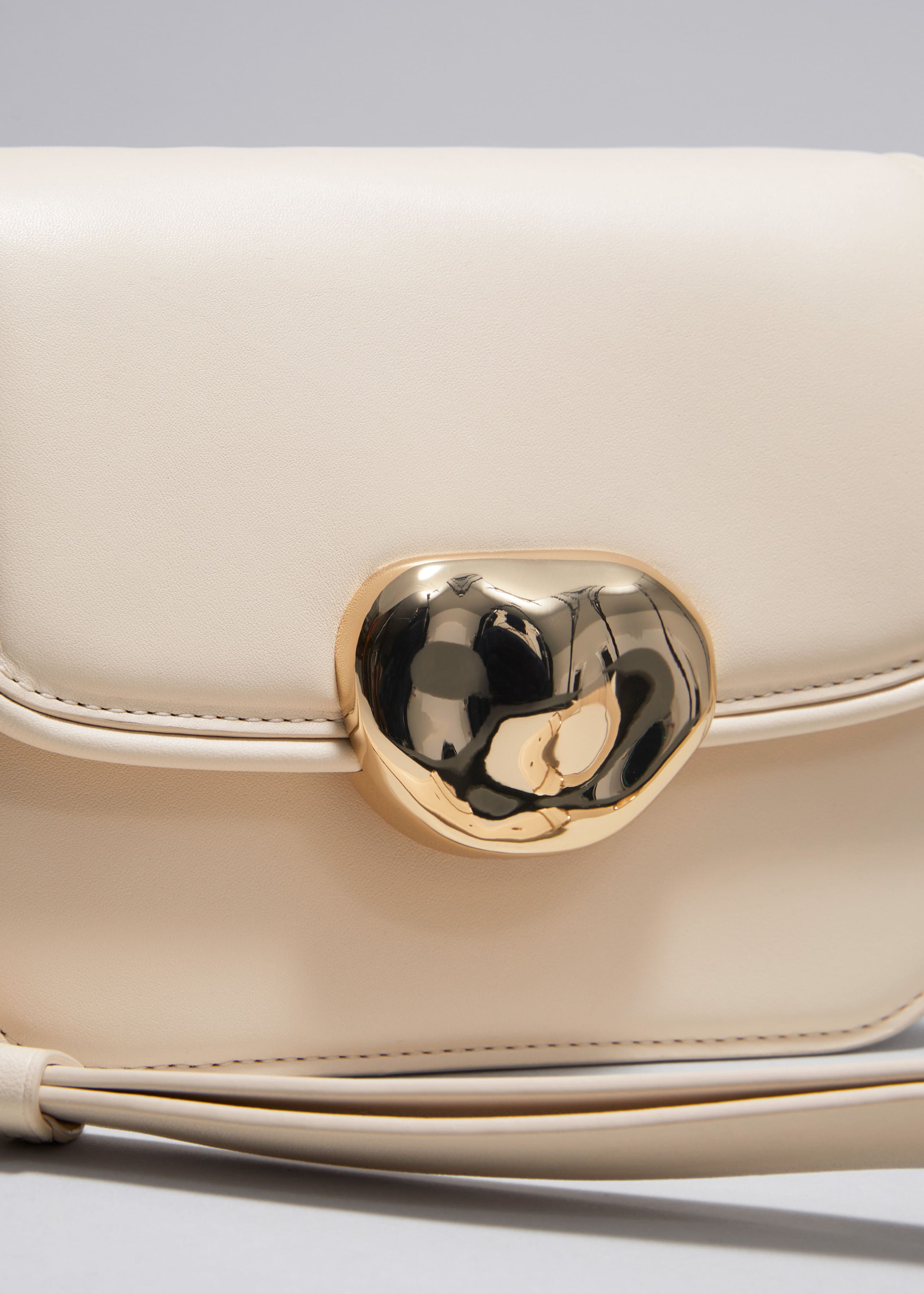 Kleine Ledertasche mit skulpturaler Schnalle - {{variantName}} - Beschreibendes Detail