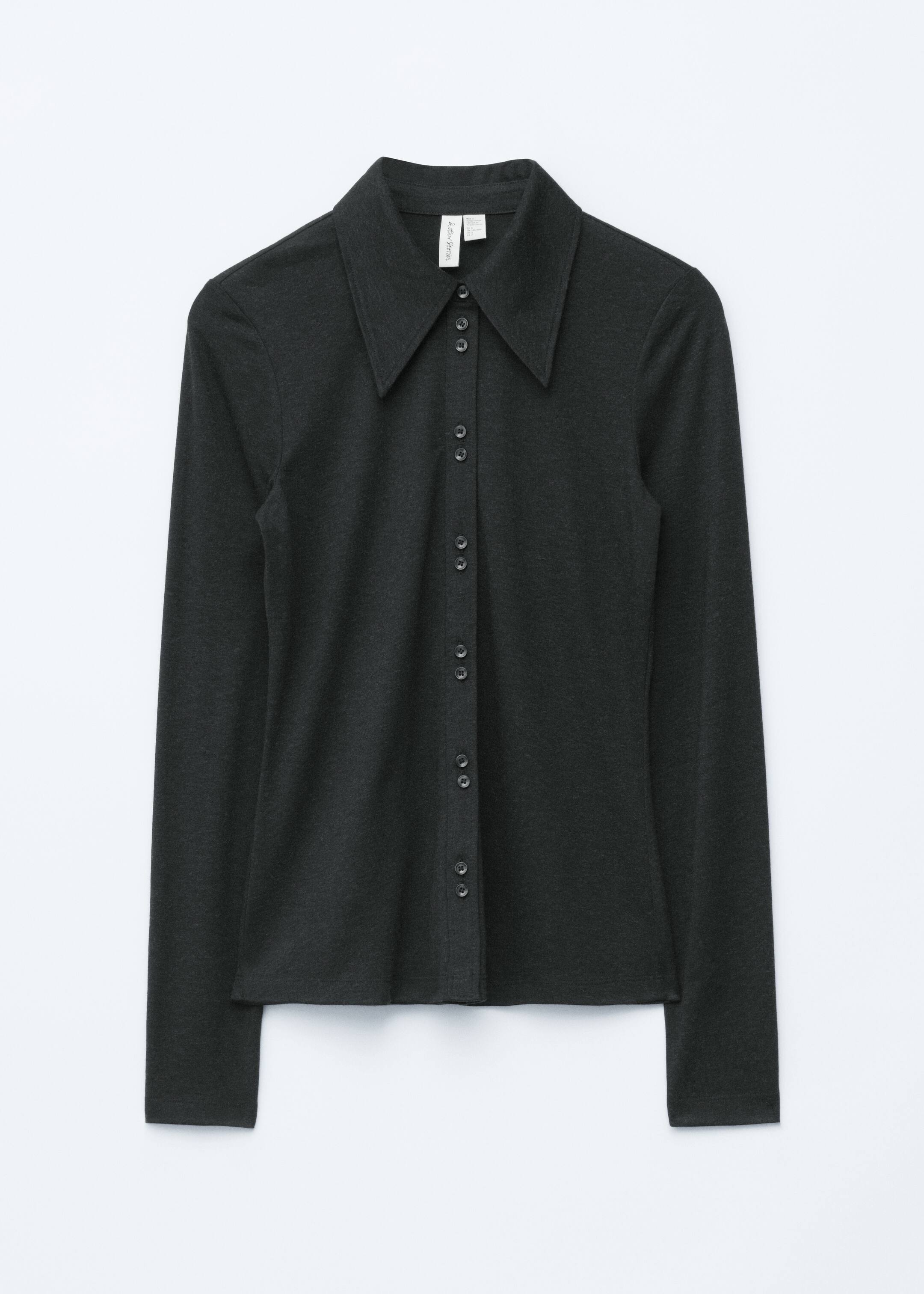 Agrandir l'image: Une chemise à manches longues gris foncé est affichée de face. Elle présente un col large et pointu ainsi qu'une patte de boutonnage complète avec de petits boutons sombres. Les manches longues se terminent par des poignets simples.