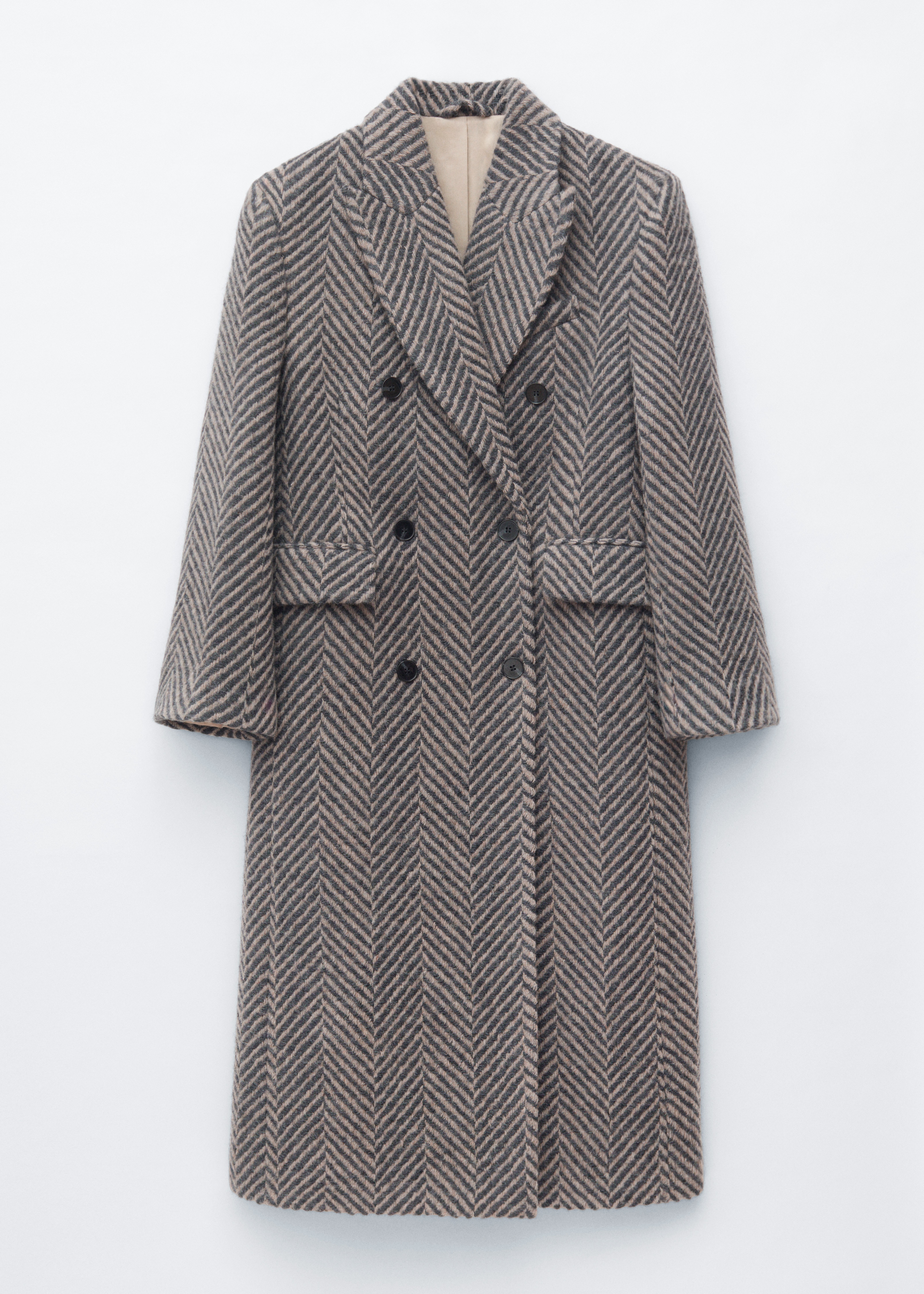 Modelka ma na sobie oversizeâowy, dwurzÄdowy pÅaszcz z szewronowym wzorem w odcieniach szaroÅci i brÄzu, z koÅnierzem z klapami typu peak lapel oraz wyraÅºnie zaznaczonÄ liniÄ ramion. DÅugi pÅaszcz zestawiono z beÅ¼owymi spodniami o szerokich nogawkach, czarnymi botkami z noskiem w szpic i okularami przeciwsÅonecznymi, a caÅoÅÄ uzupeÅnia ciemnopurpurowa torebka na ramiÄ.