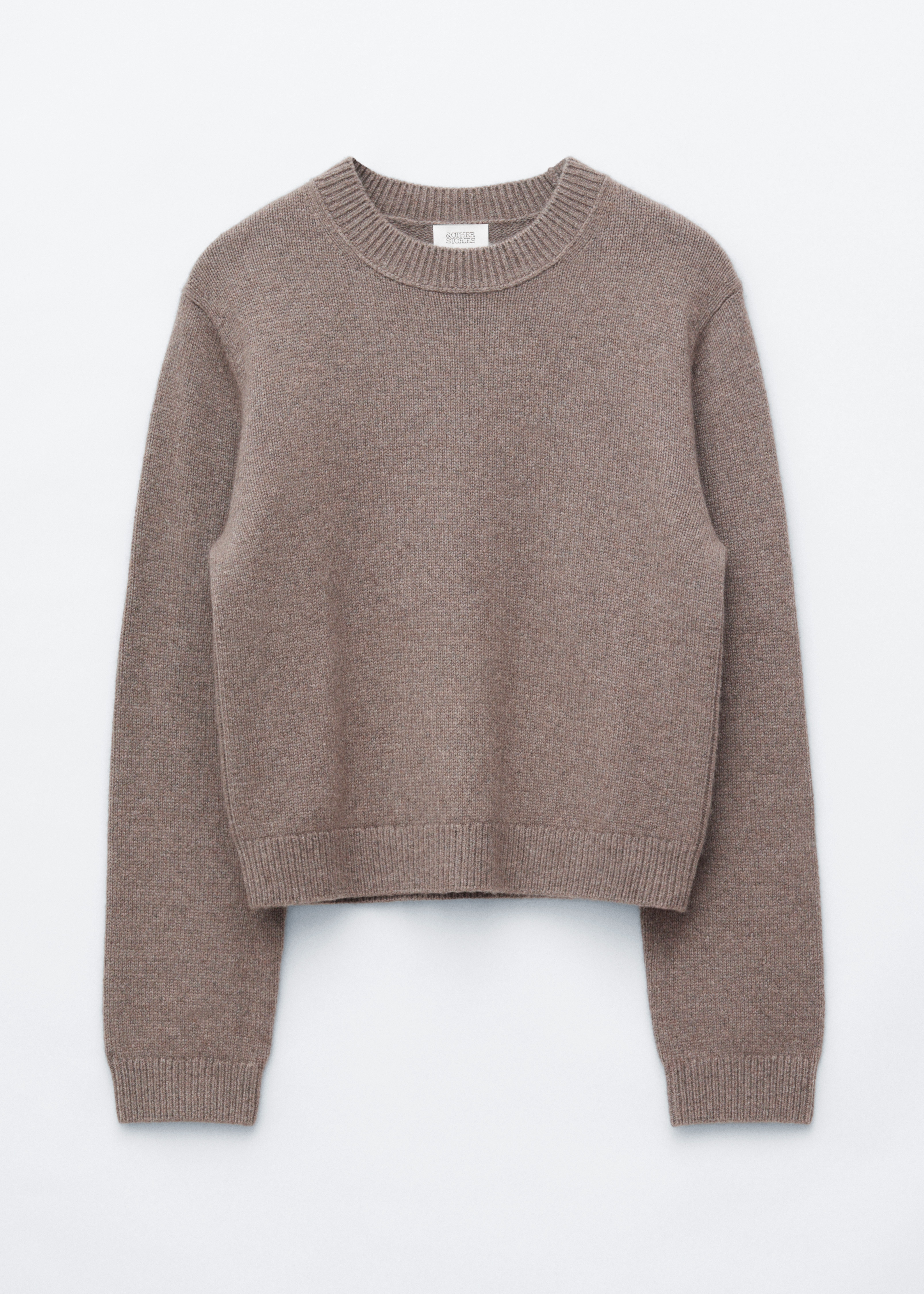 Ein Pullover aus Kaschmirmischung in Taupebraun wird vom Model getragen und zeichnet sich durch einen gerippten Rundhalsausschnitt, BÃ¼ndchen sowie eine lockere Passform aus. Der Pullover ist in eine schwarze Wide-Leg-Jeans gesteckt, dazu wird eine schwarze Leder-UmhÃ¤ngetasche Ã¼ber der Schulter getragen.