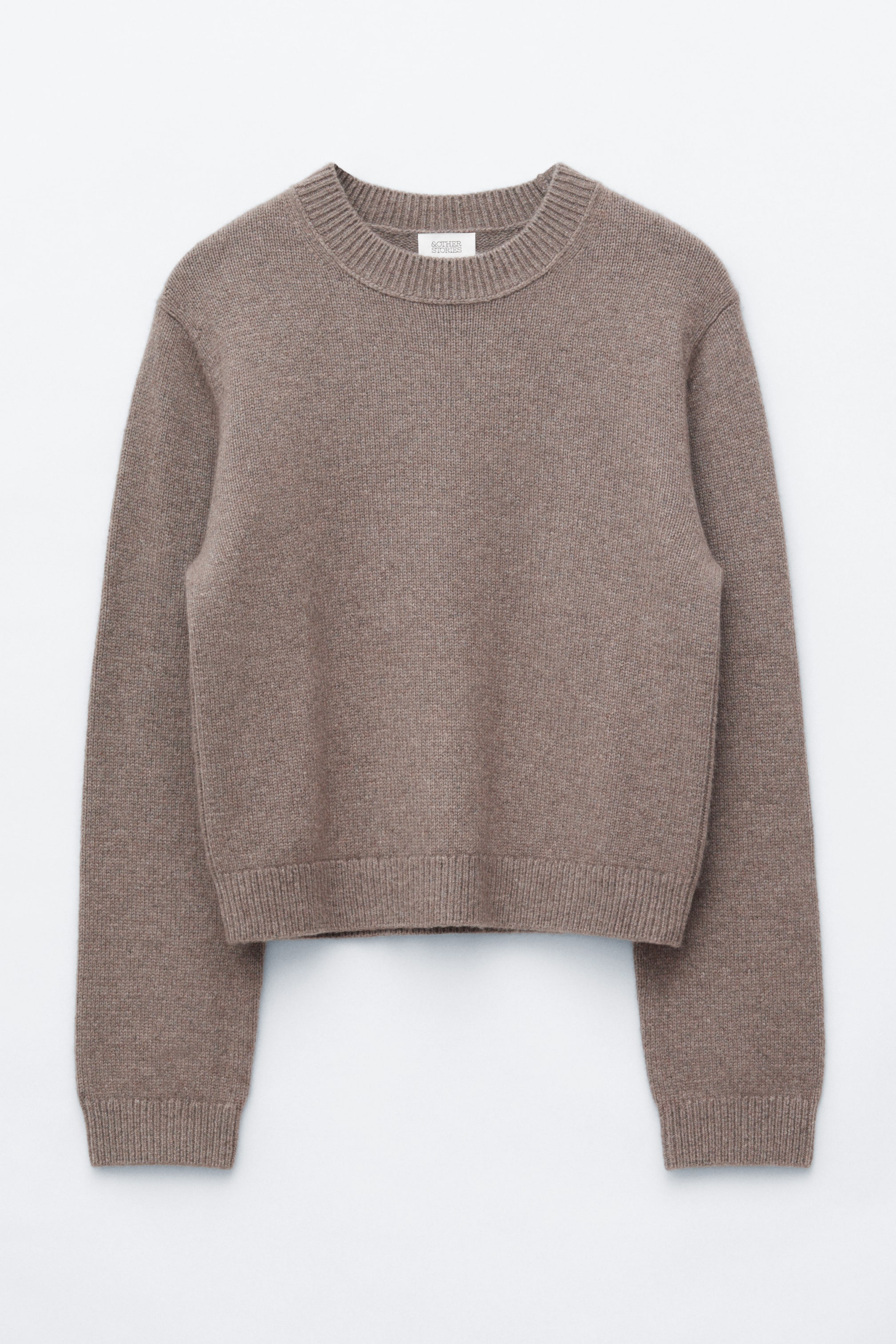 View larger image: A taupe short jumper is shown from the front, featuring a ribbed crew neck, gently dropped shoulders, ribbed cuffs, and a ribbed hem.