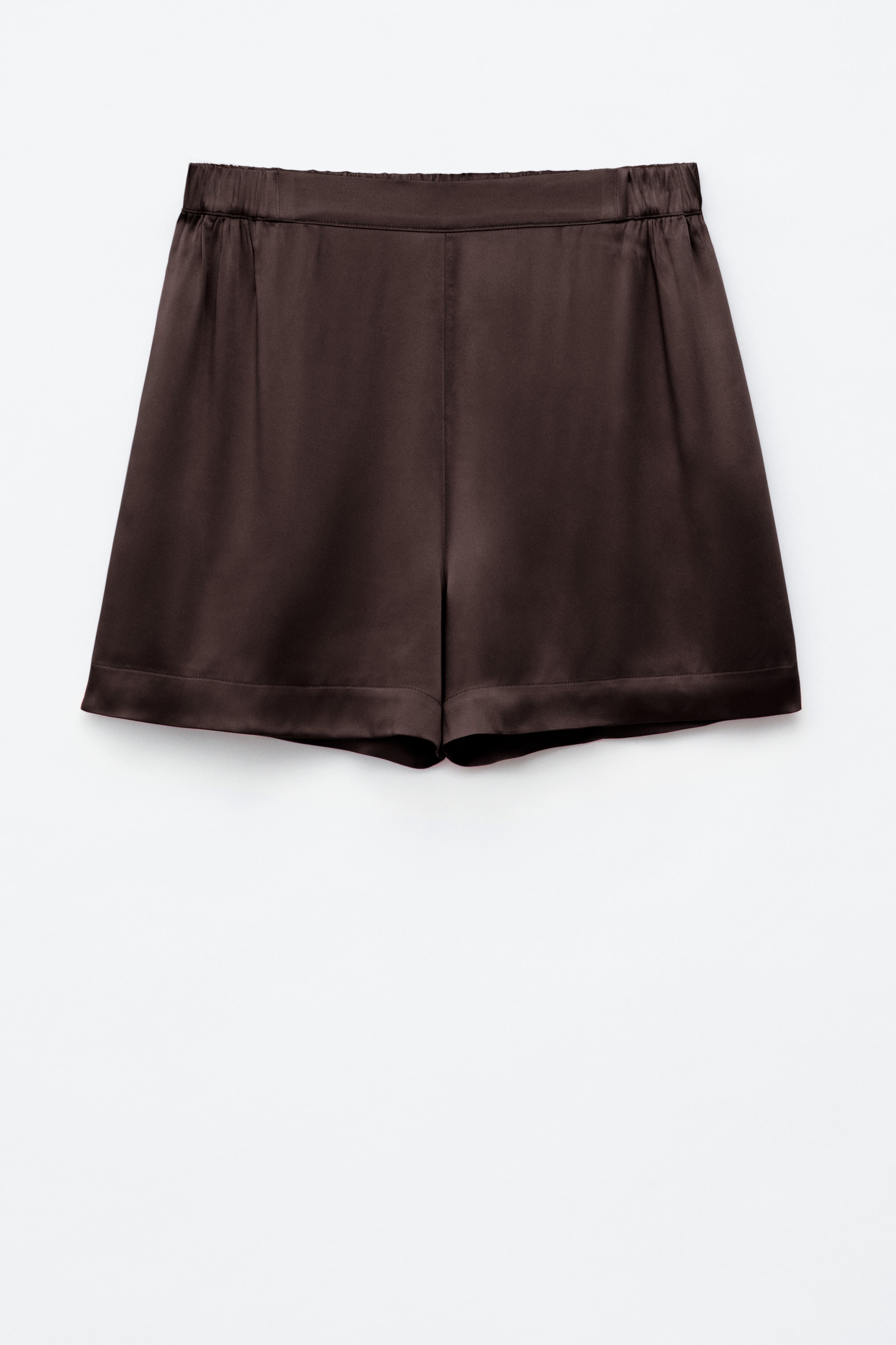 Se større billede: Brune satinshorts viser en skinnende finish og en afslappet silhuet, set forfra. De har en samlet høj talje med elastikbånd og en ren afsluttet kant.