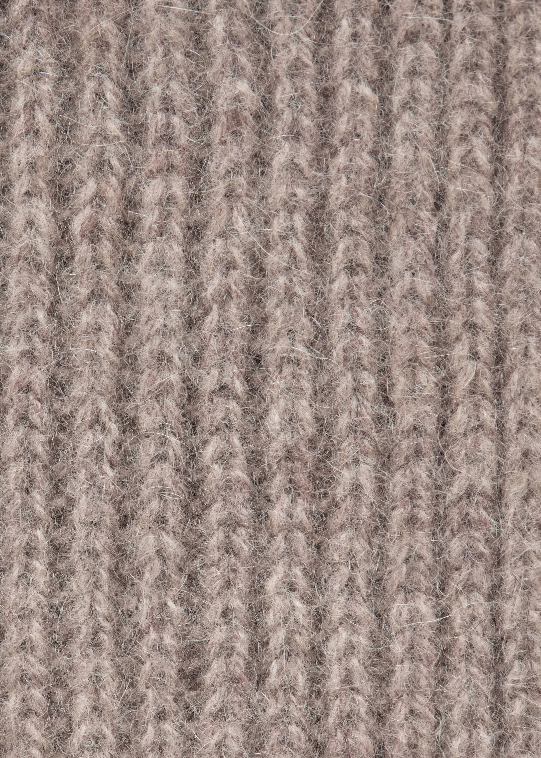 Grösseres Bild ansehen: Der Kaschmirstrickschal präsentiert eine gerippte Struktur in einem hellbeigen Farbton. Feine, weiche Fasern detaillieren sichtbar die Strickoberfläche.
