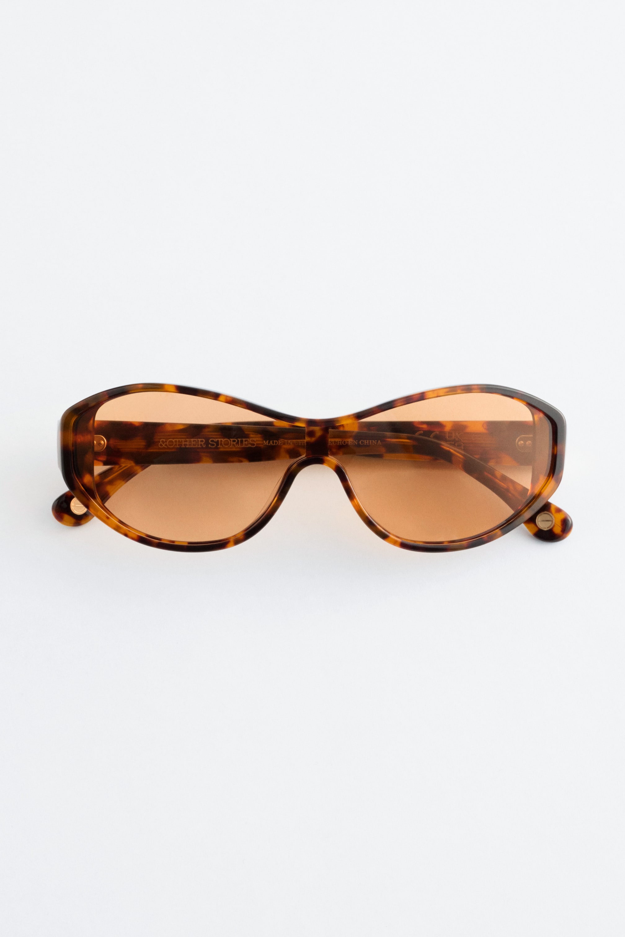 Ver imagen más grande: Las gafas de sol están orientadas al frente, con distintivas monturas ovaladas de acetato en carey y lentes tintadas en marrón claro.