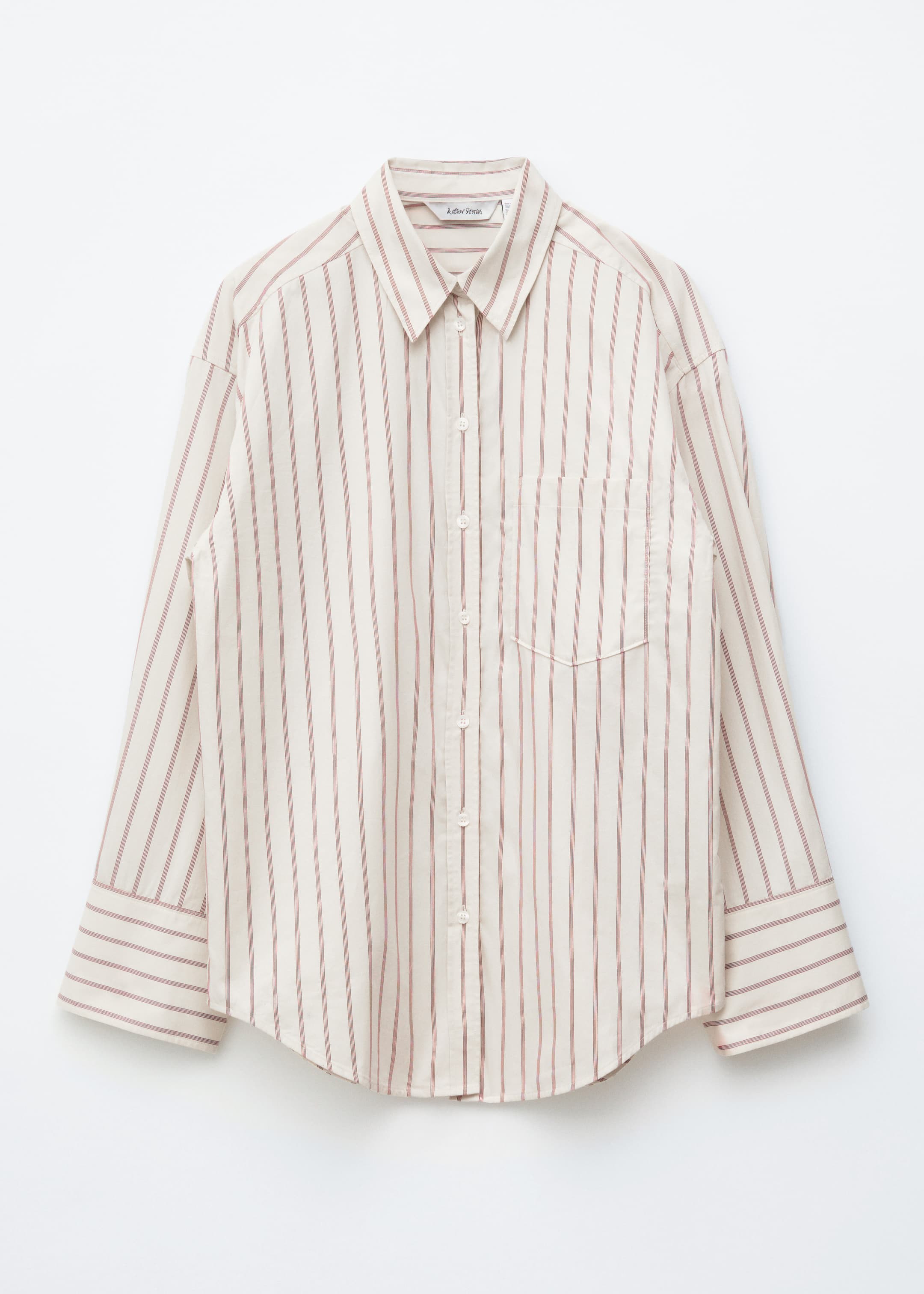 Visualizza immagine più grande: È presentata una camicia frontale, caratterizzata da una base beige con sottili righe verticali marrone-rossiccio. È disegnata con un colletto a punta, una chiusura frontale con bottoni in tinta, maniche lunghe con polsini ampi con bottoni, e una tasca a toppa sul petto sinistro. La camicia presenta una vestibilità rilassata e cuciture impunturate su tutta la superficie.