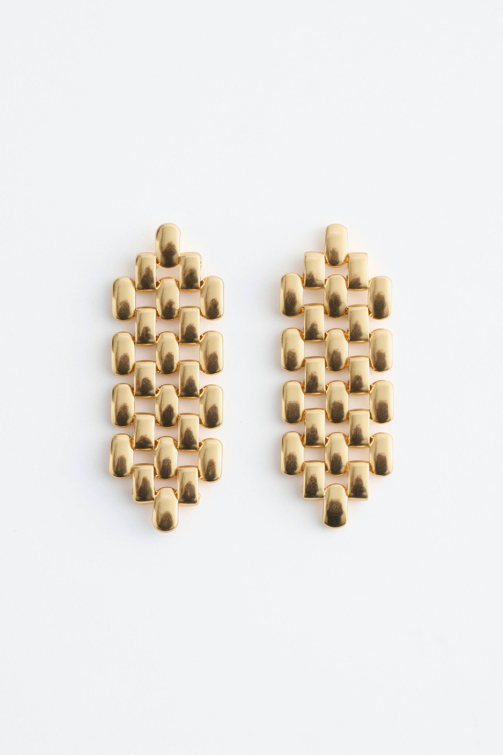 View larger image: A pair of golden pendant earrings featuring an architectural chain pattern, crafted from numerous interlinked, rounded rectangular links, tapering to a point at both the top and bottom ends.