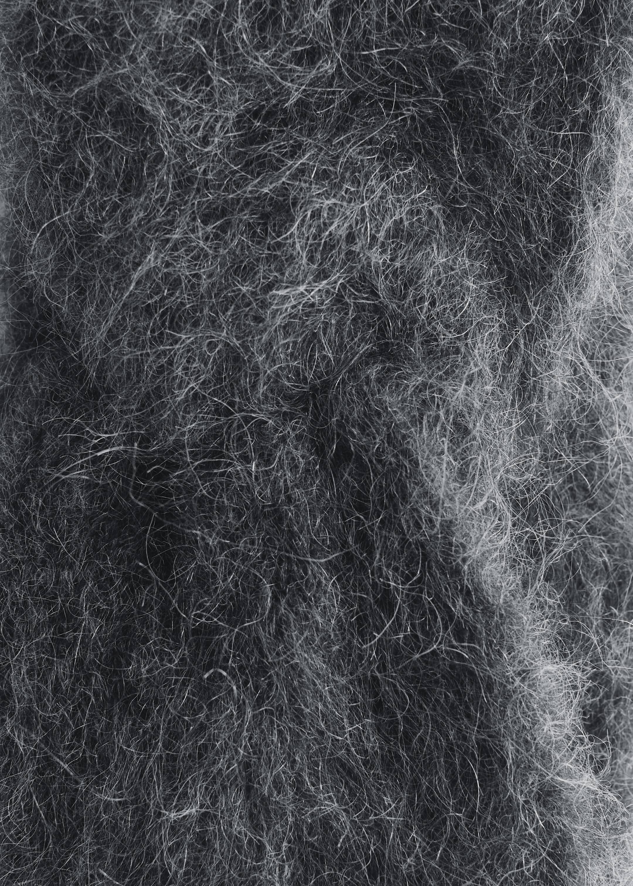 View larger image: Mohair-Blend Twist-Front Headband material is being presented in a close-up, showcasing its soft, fuzzy texture. Long, fine fibers are appearing in varying shades of gray, forming a dense, hairy surface.