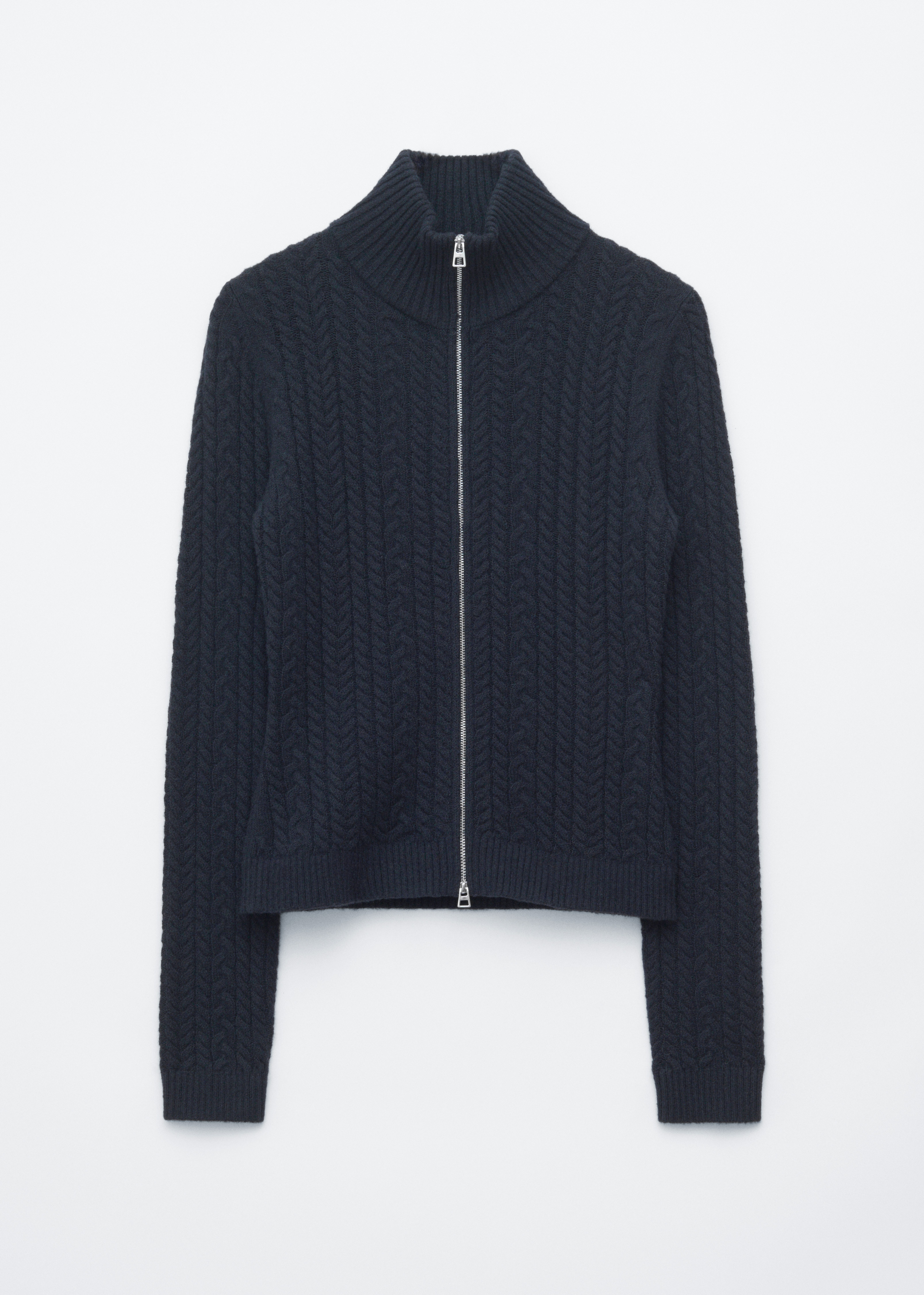 Ένα σκούρο γκρι, ανάμεικτο cable-knit cardigan φοριέται από το μοντέλο, σε layering πάνω από μαύρο ζιβάγκο και συνδυασμένο με γκρι παντελόνι. Το slim-fit cardigan διαθέτει ψηλό, διπλής στρώσης ribbed γιακά και ασημί two-way μπροστινό φερμουάρ, το οποίο είναι μερικώς ανοιχτό και στα δύο άκρα.