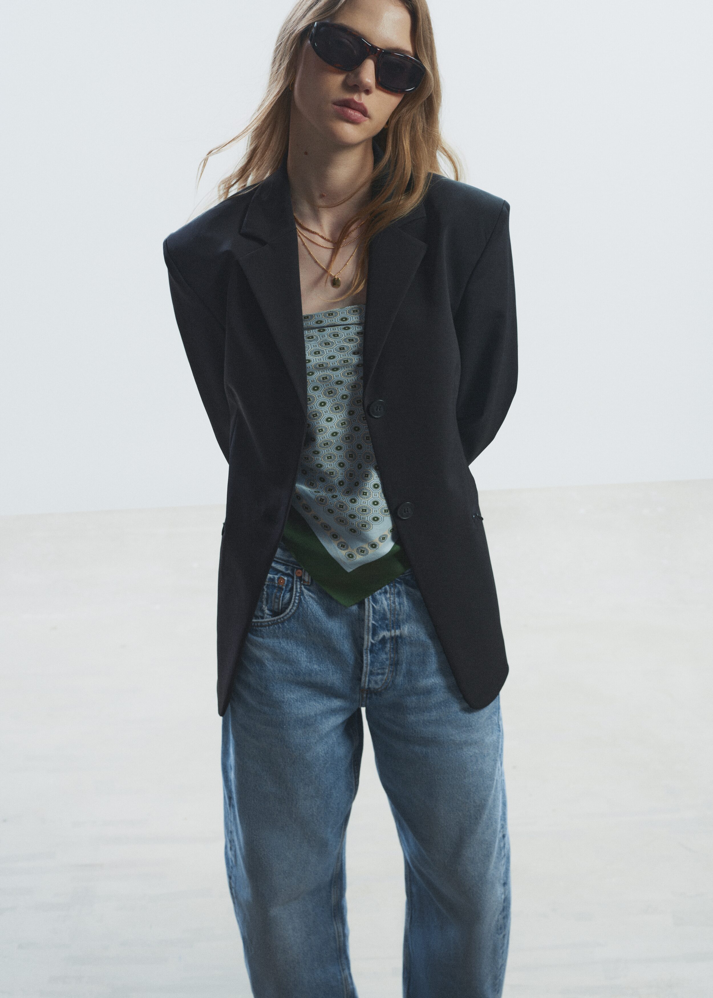 Ein Paar Jeans in hellblauer Waschung wird VON VORN präsentiert, mit einem klassischen 5-Taschen-Design und einer Knopfleiste. Die Jeans zeichnen sich durch eine übergroße Passform mit fassförmigen, extralangen Beinen aus, die mit breiten, am Saum hochgekrempelten Bündchen gestylt sind.