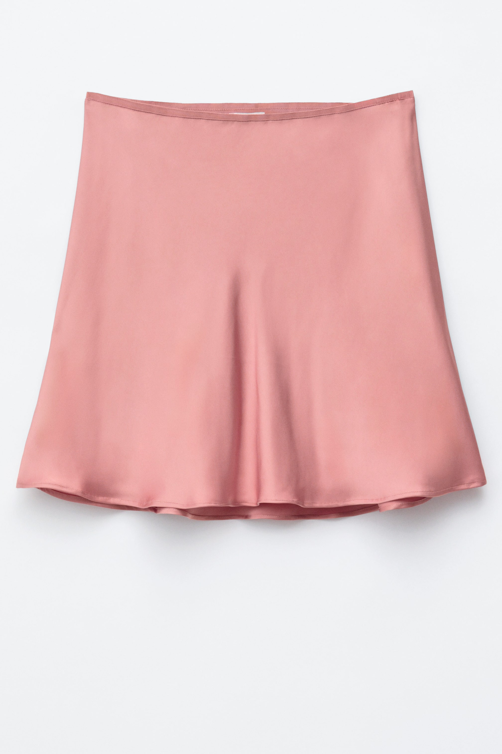 Visualizza immagine più grande: Una gonna a trapezio rosa rosa è presentata frontalmente, mostrando il suo materiale liscio e fluido e una delicata fascia elastica in vita.