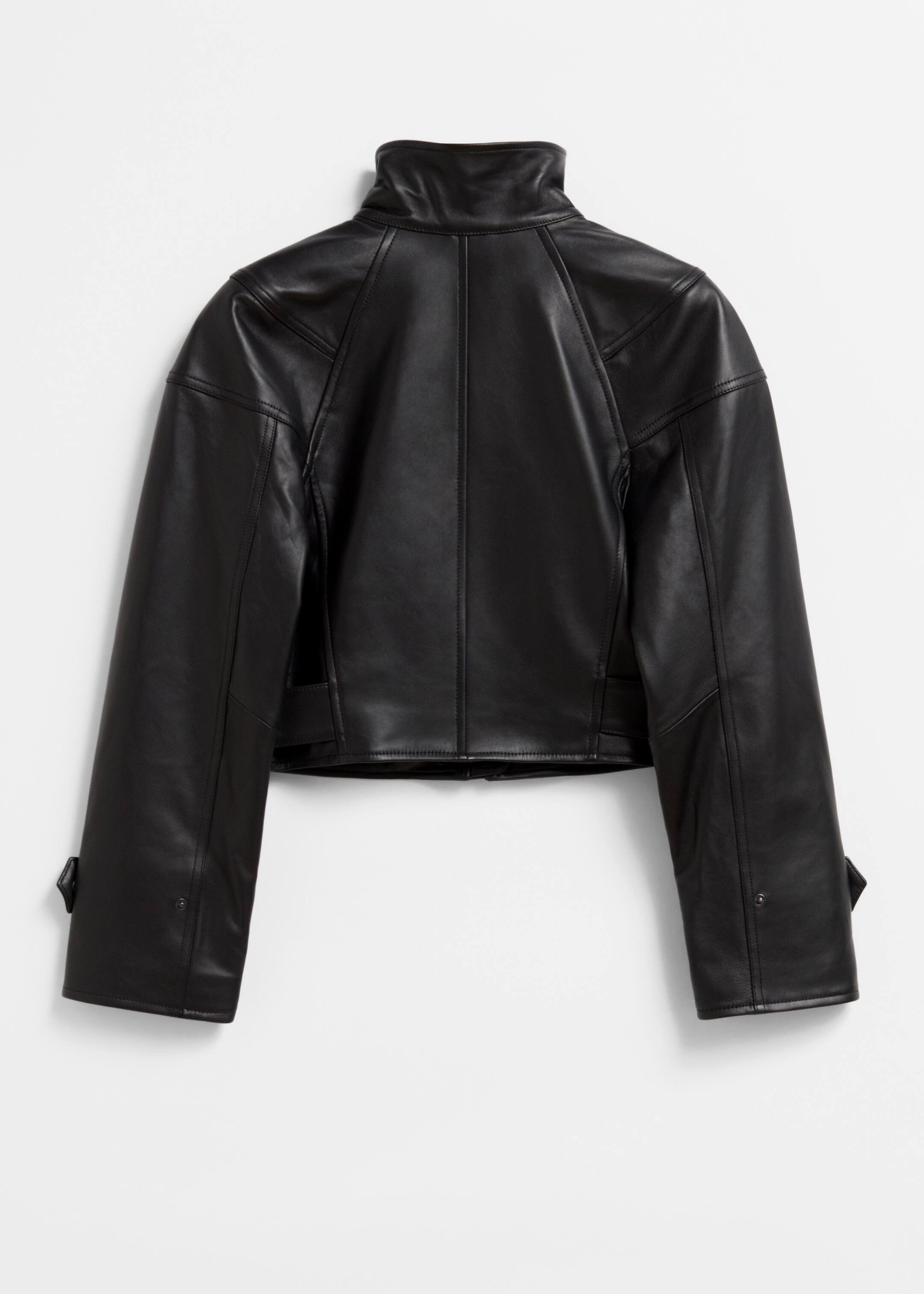 Größeres Bild ansehen: Eine schwarze, gekürzte Lederjacke wird von hinten gezeigt, mit einem glatten Finish und einem Stehkragen. Sie zeigt strukturierte, abgerundete Schultern, Panelnähte auf dem Rücken und den Ärmeln sowie Druckknopflaschen an den Manschetten.