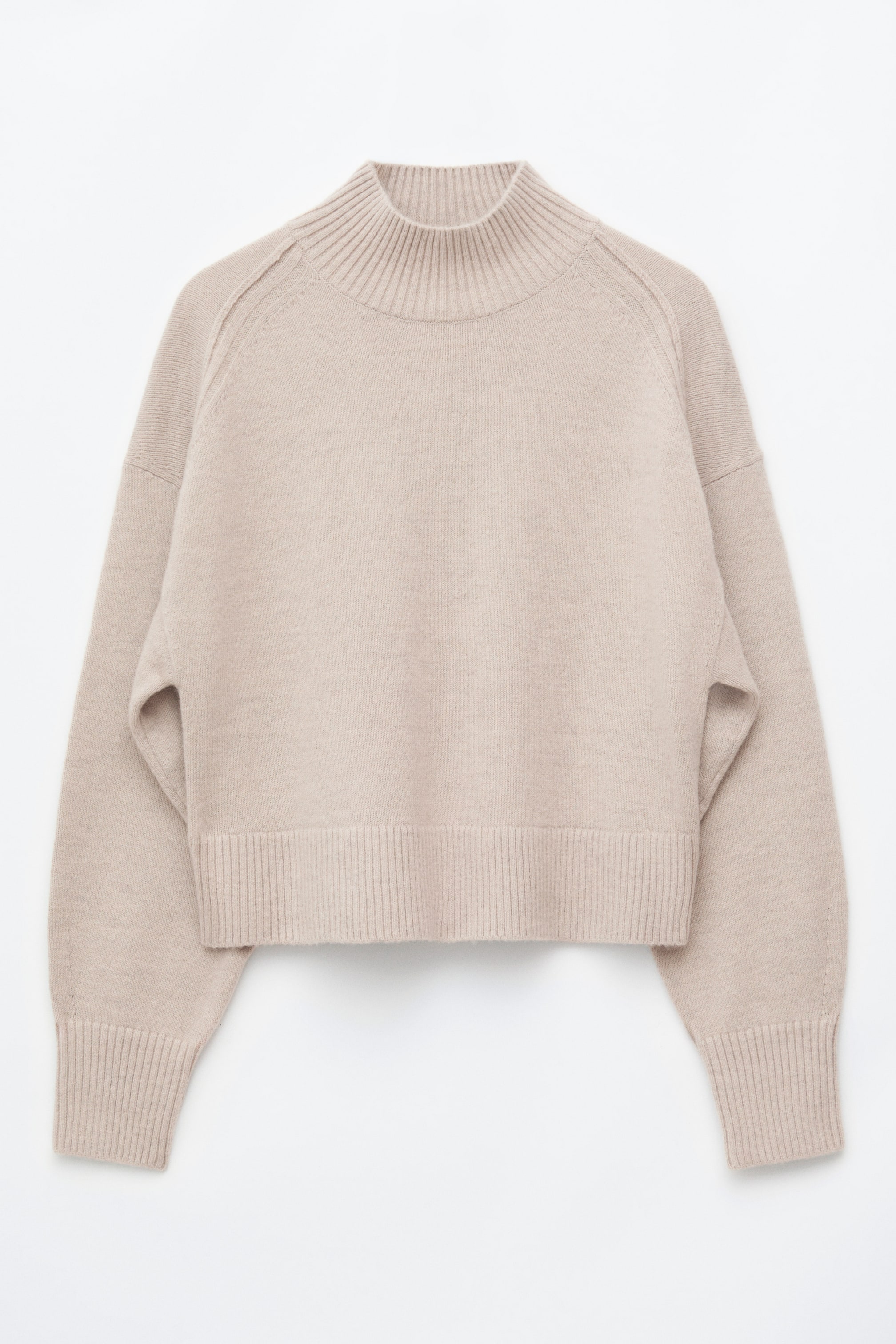 Ver imagen más grande: Un jersey beige con cuello subido está de frente, mostrando una silueta relajada con costuras de los hombros orientadas hacia delante. Presenta un cuello acanalado, un bajo acanalado ancho y mangas largas con puños acanalados extendidos.
