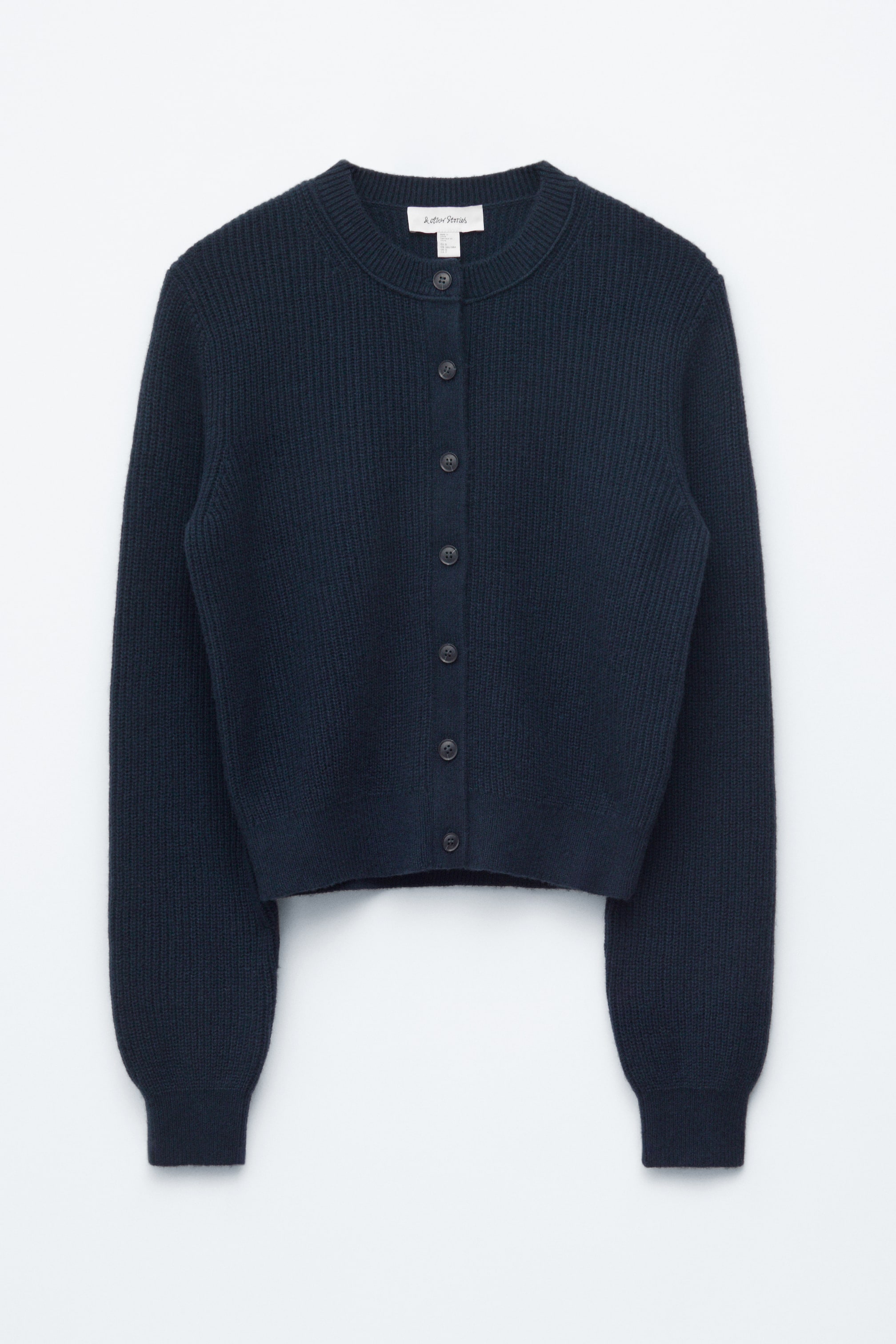 Visualizza l'immagine ingrandita: Un cardigan a maglia a coste blu scuro è mostrato dal davanti, caratterizzato da un collo tondo, una chiusura frontale con sette bottoni scuri, maniche lunghe con polsini a coste e un orlo a coste.