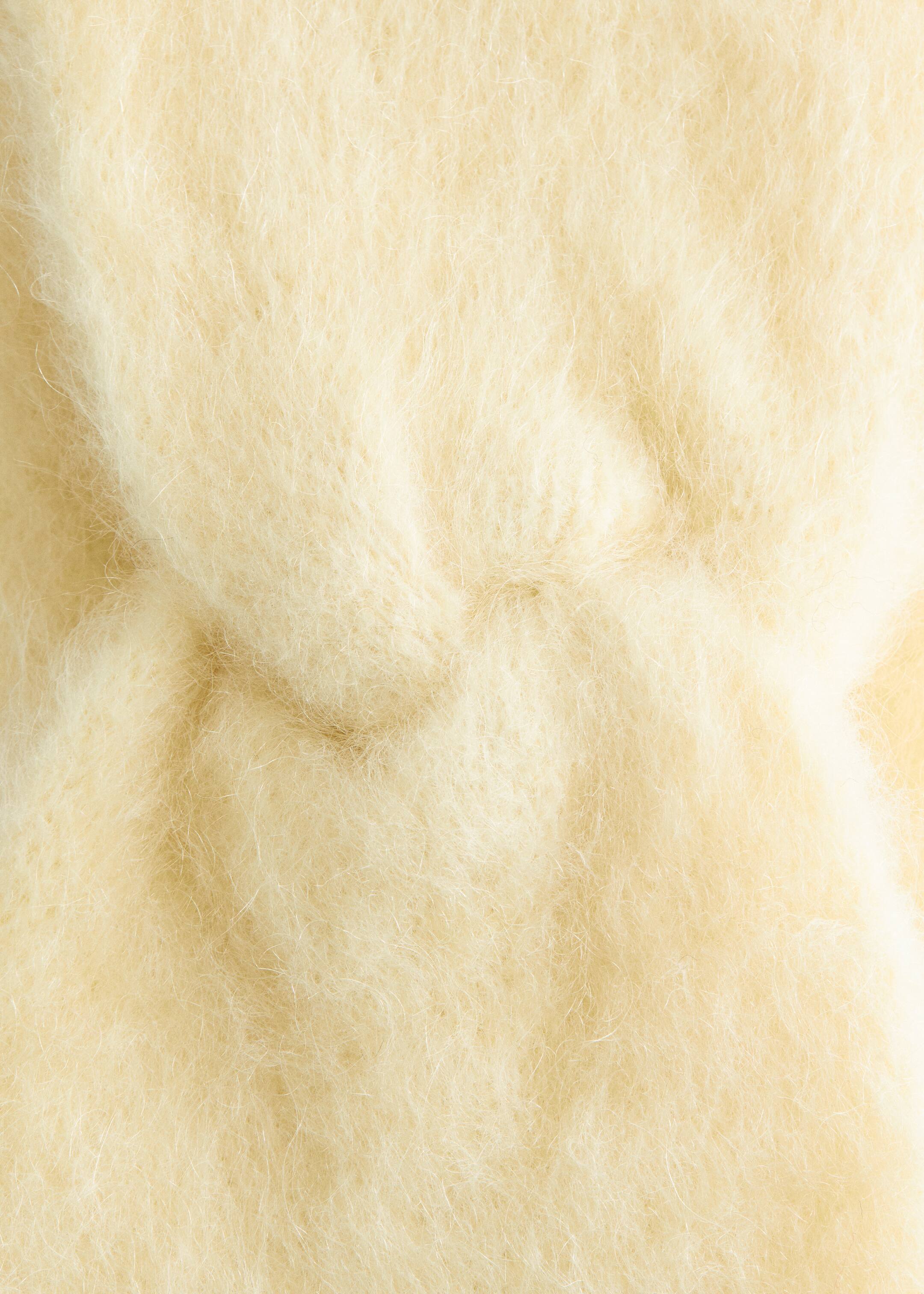Ver imagem maior: A Bandolete de Mohair com Torção é apresentada em close-up do seu tecido, exibindo uma textura suave e felpuda com longas fibras amarelo-pálido que mostram variações sutis de profundidade.