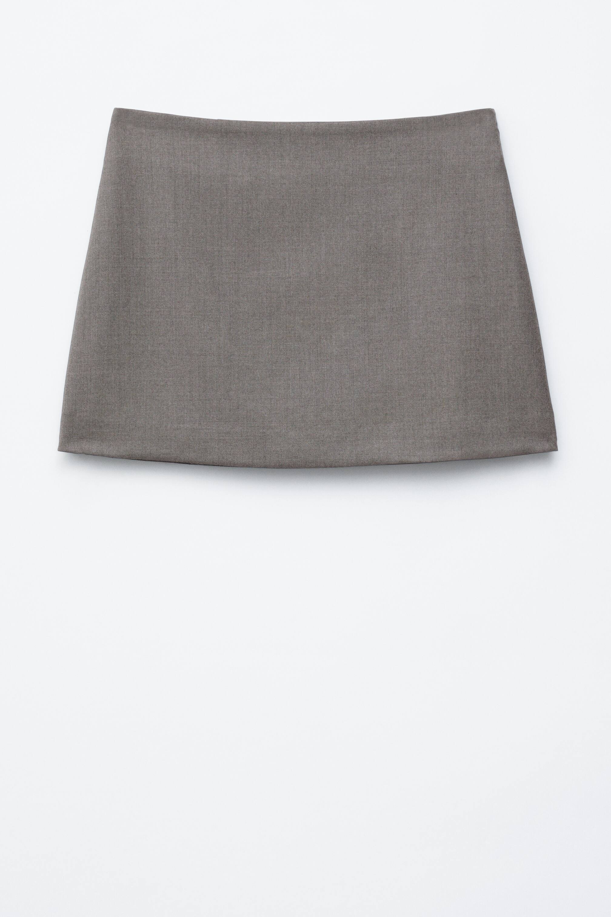 Agrandir l'image: Une jupe mini en sergé gris foncé léger présente une silhouette A-line épurée et minimaliste, avec une ceinture plate à taille mi-haute, et orientée FACE.