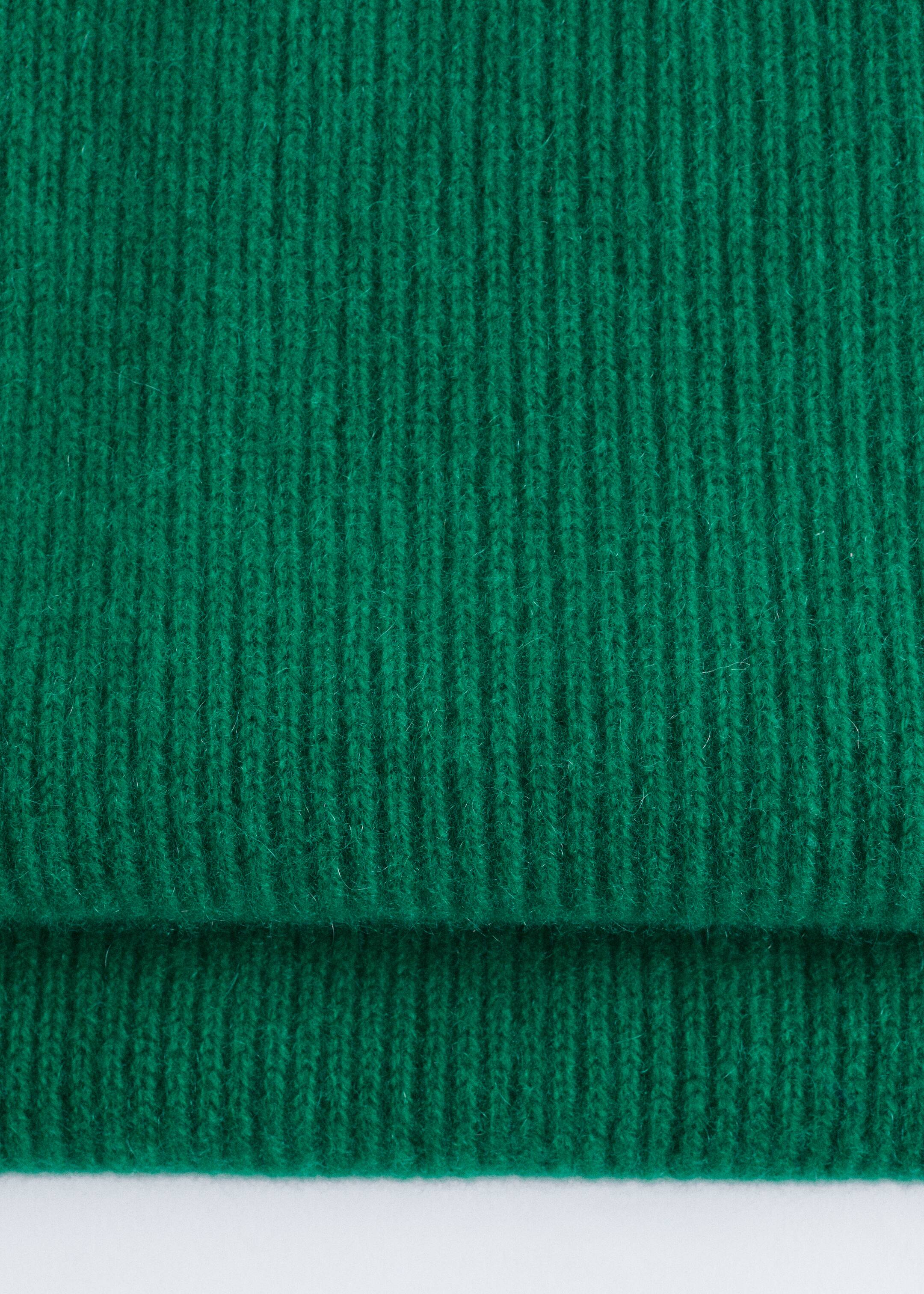 Agrandir l'image: Une écharpe en cachemire tricotée vert foncé est présentée, affichant une texture côtelée distincte et pliée horizontalement.