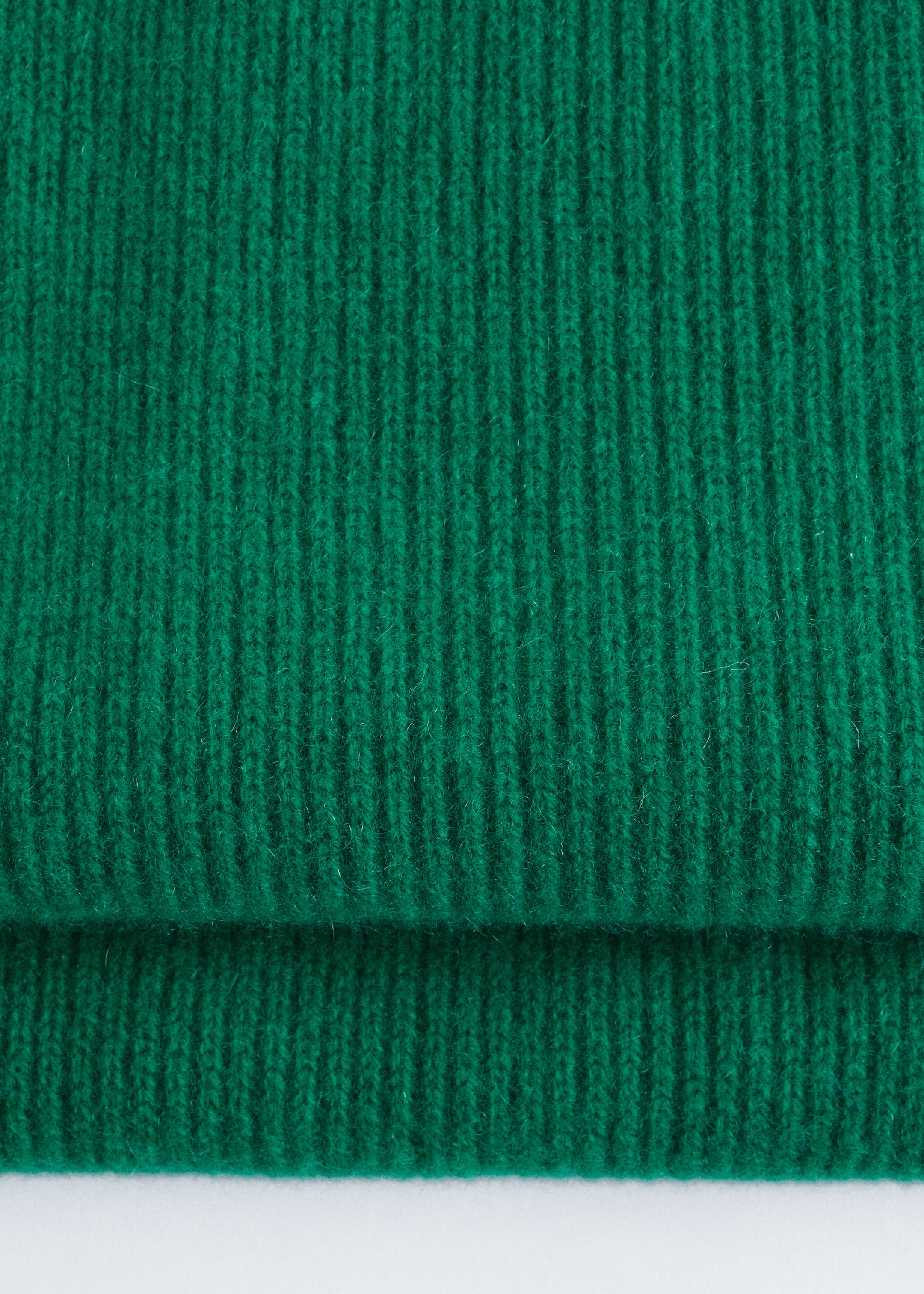 Visualizza immagine più grande: Una sciarpa in maglia di cashmere verde scuro viene presentata, mostrando una distintiva trama a coste e piegata orizzontalmente.