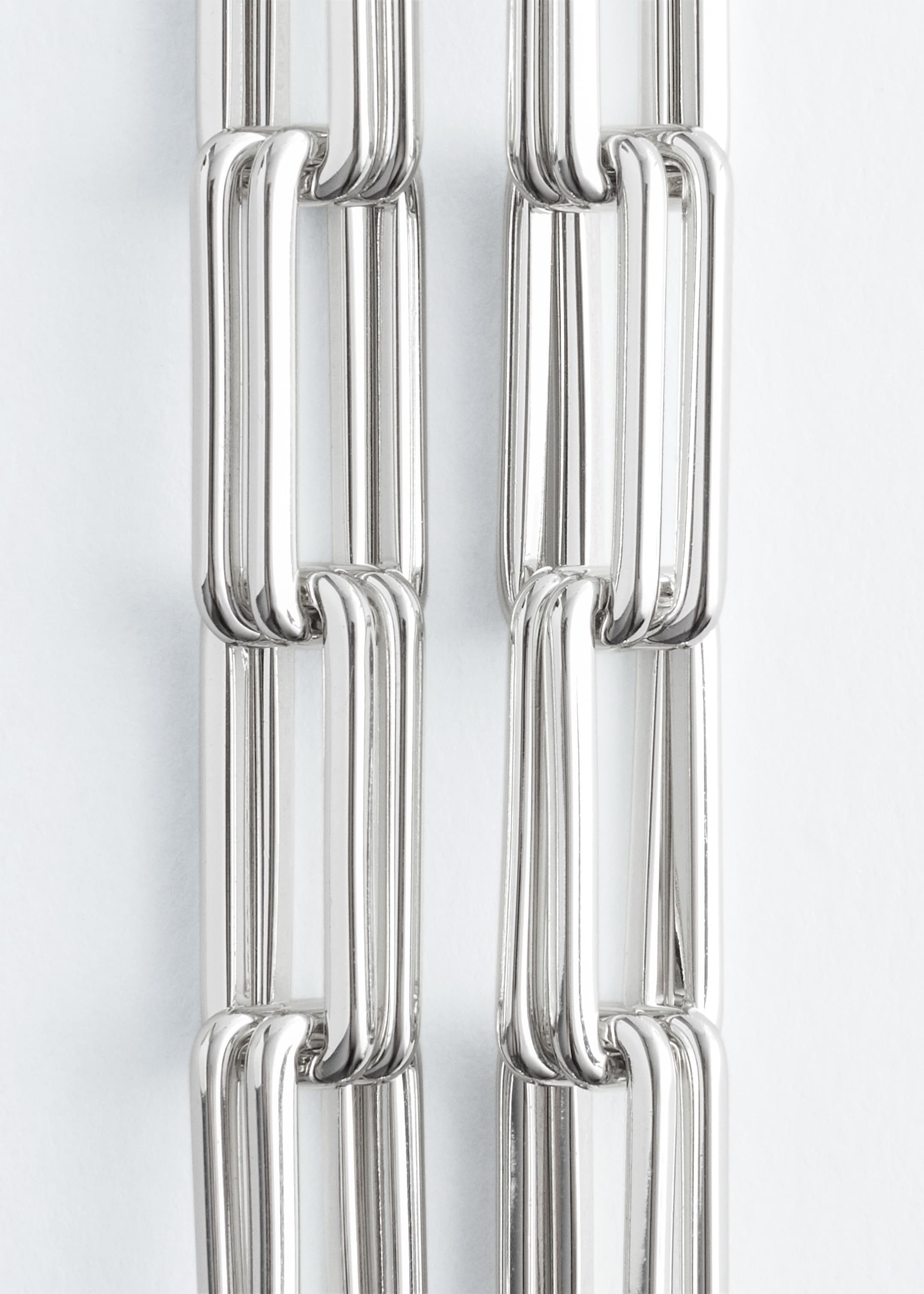 Agrandir l'image: Un collier à maillons épais est présenté, avec des maillons rectangulaires allongés et épais aux coins arrondis. Les maillons sont polis et semblent tubulaires, affichant une finition métallique argentée et brillante.