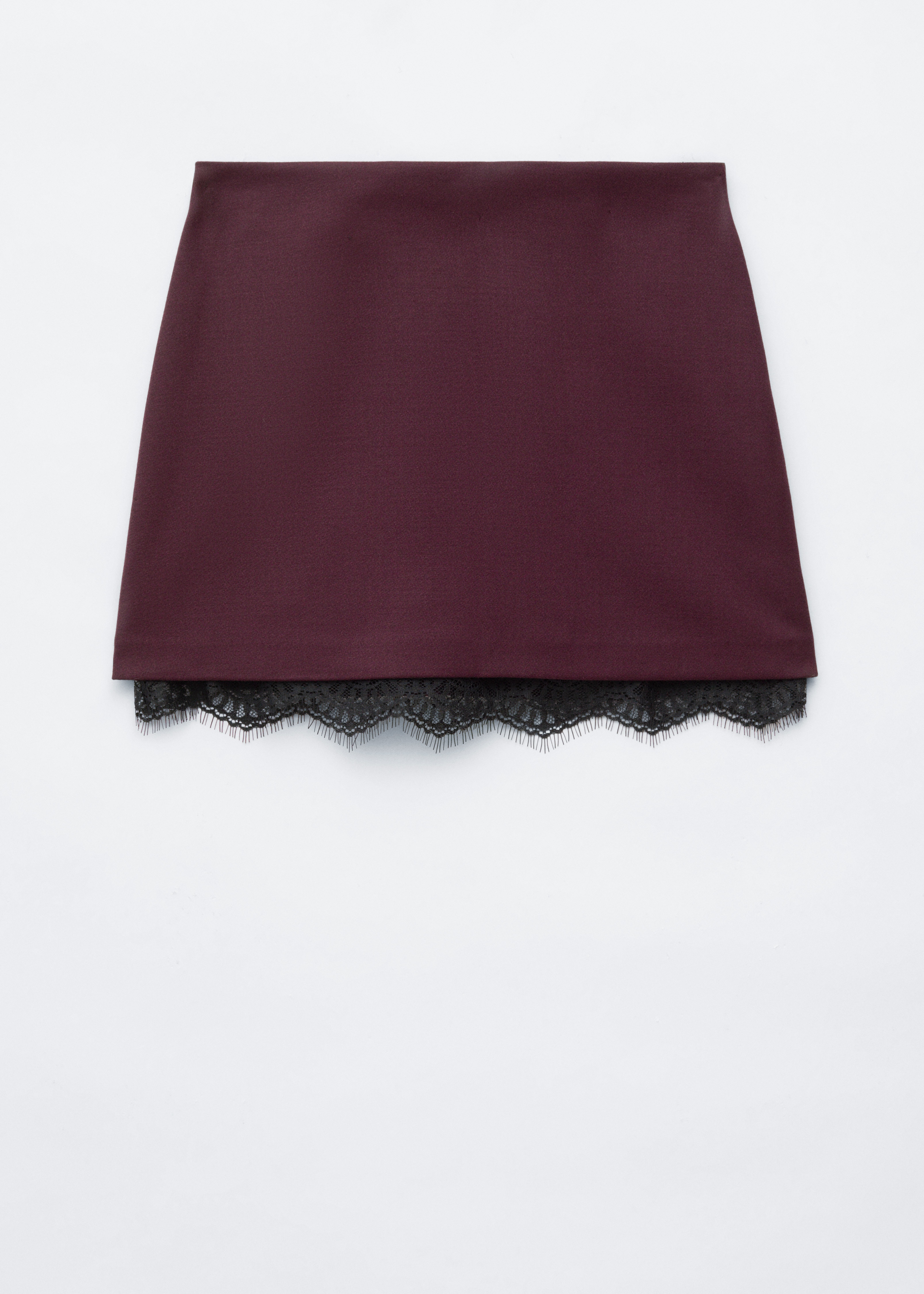 A burgundy mini skirt featuring delicate black lace trim along the hem is being worn by the model. The skirt is styled with an oversized black roll-neck sweater and sheer black tights.