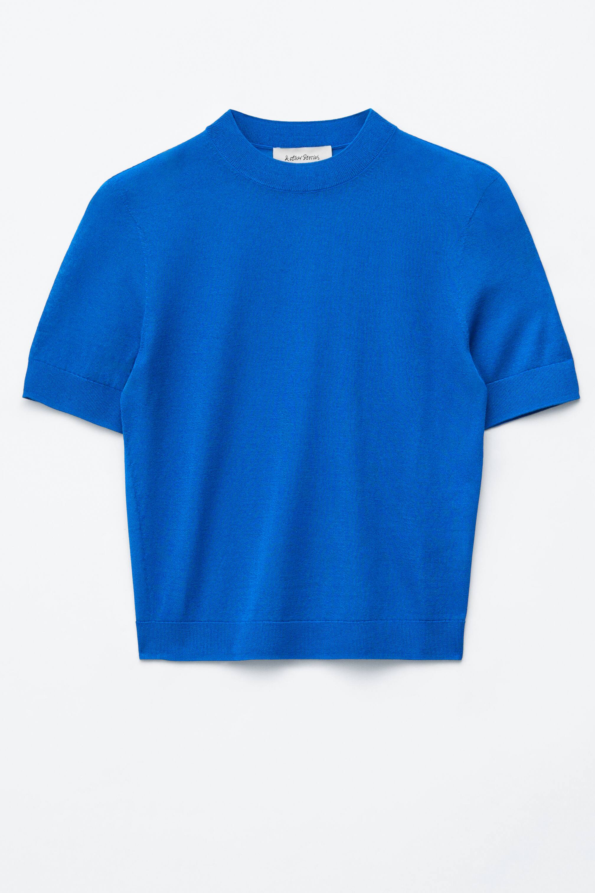 View larger image: A vibrant blue short-sleeve knit top is showcased FRONT, featuring a mock neck and short cuffed sleeves. Its hem finishes straight.