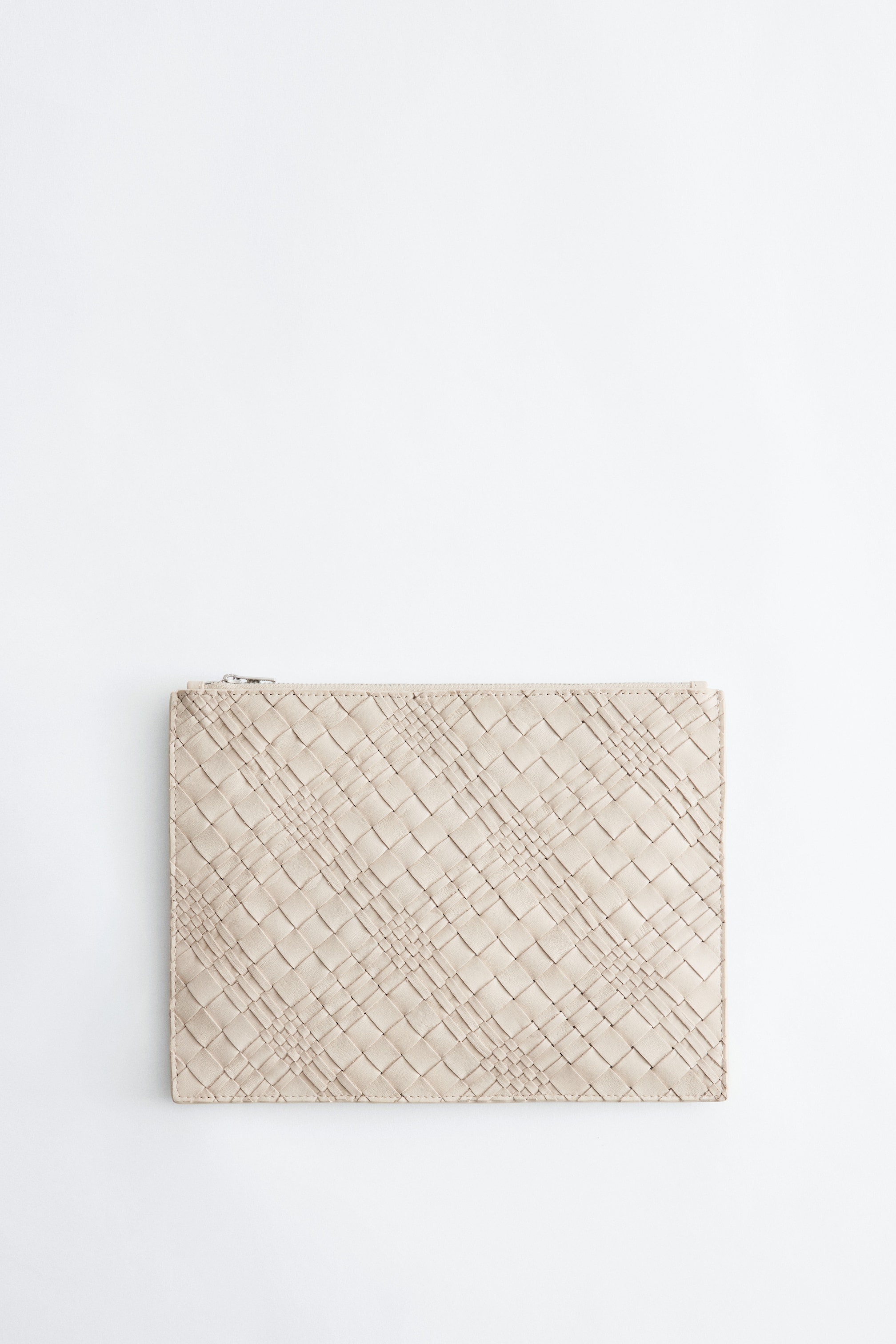 Visualizza immagine più grande: Portafoglio in Pelle Intrecciata è di colore beige chiaro, caratterizzato da un motivo intrecciato sulla superficie frontale. Una chiusura con cerniera argentata è visibile lungo il bordo superiore.