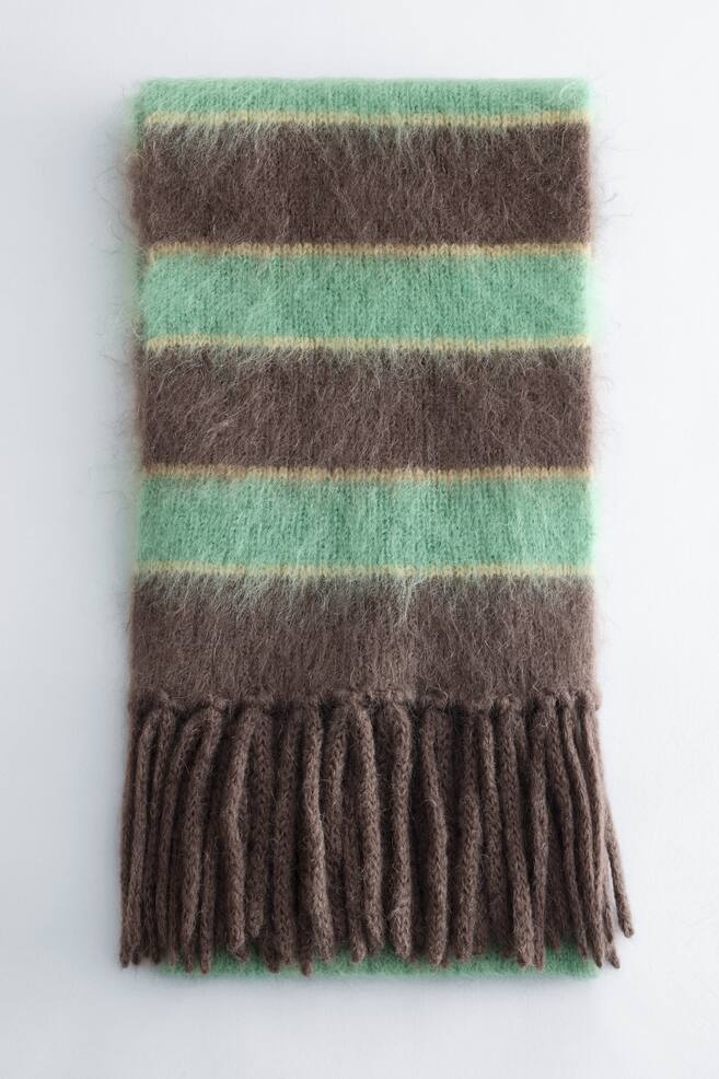 A knitted scarf displays a fuzzy, brushed texture with wide horizontal stripes of chocolate brown and mint green, separated by thin yellow lines. The scarf features thick, twisted brown fringes along its lower edge. - 1