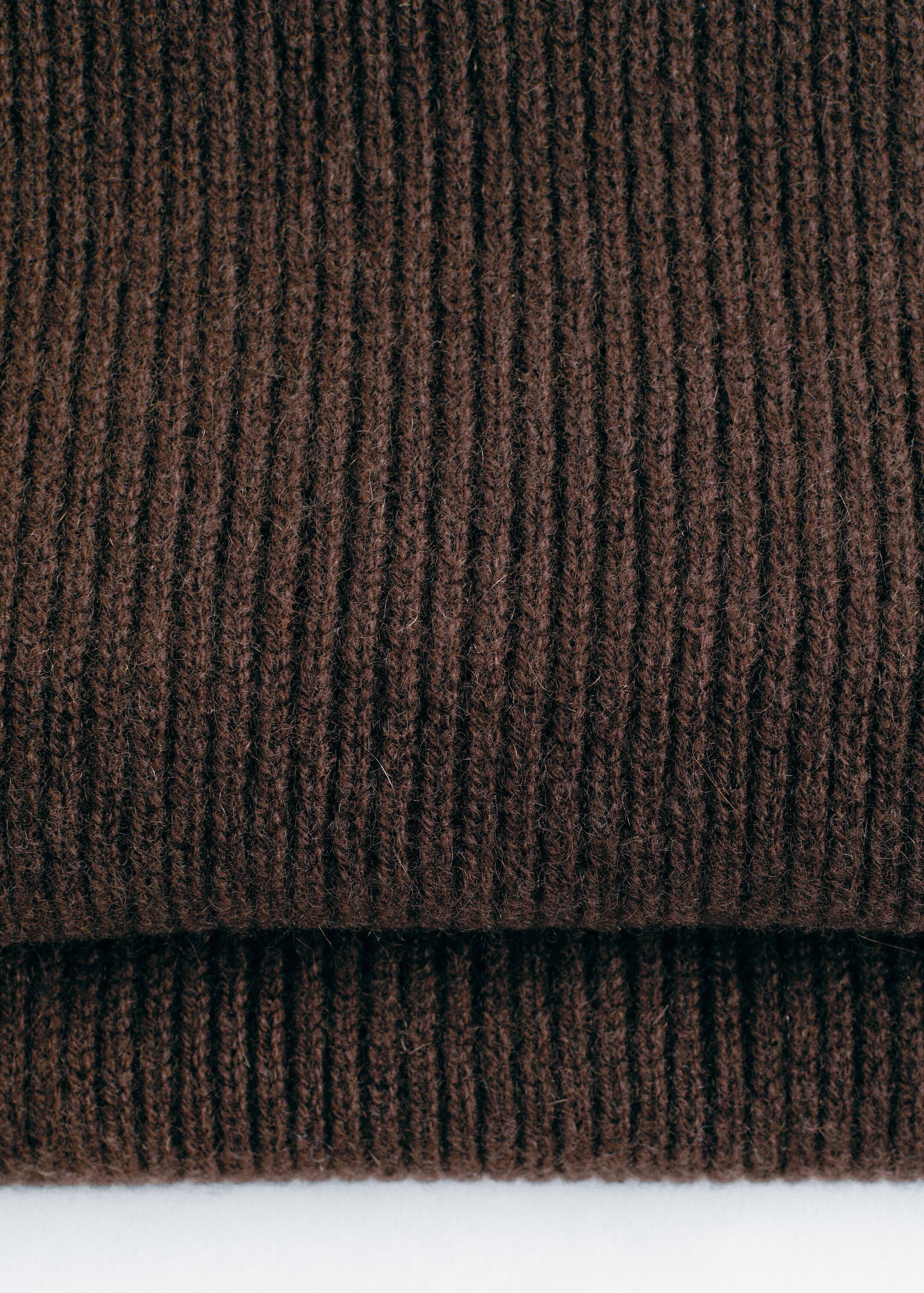 Agrandir l'image: Une écharpe en tricot brun foncé est pliée, montrant son motif côtelé vertical à travers deux couches.