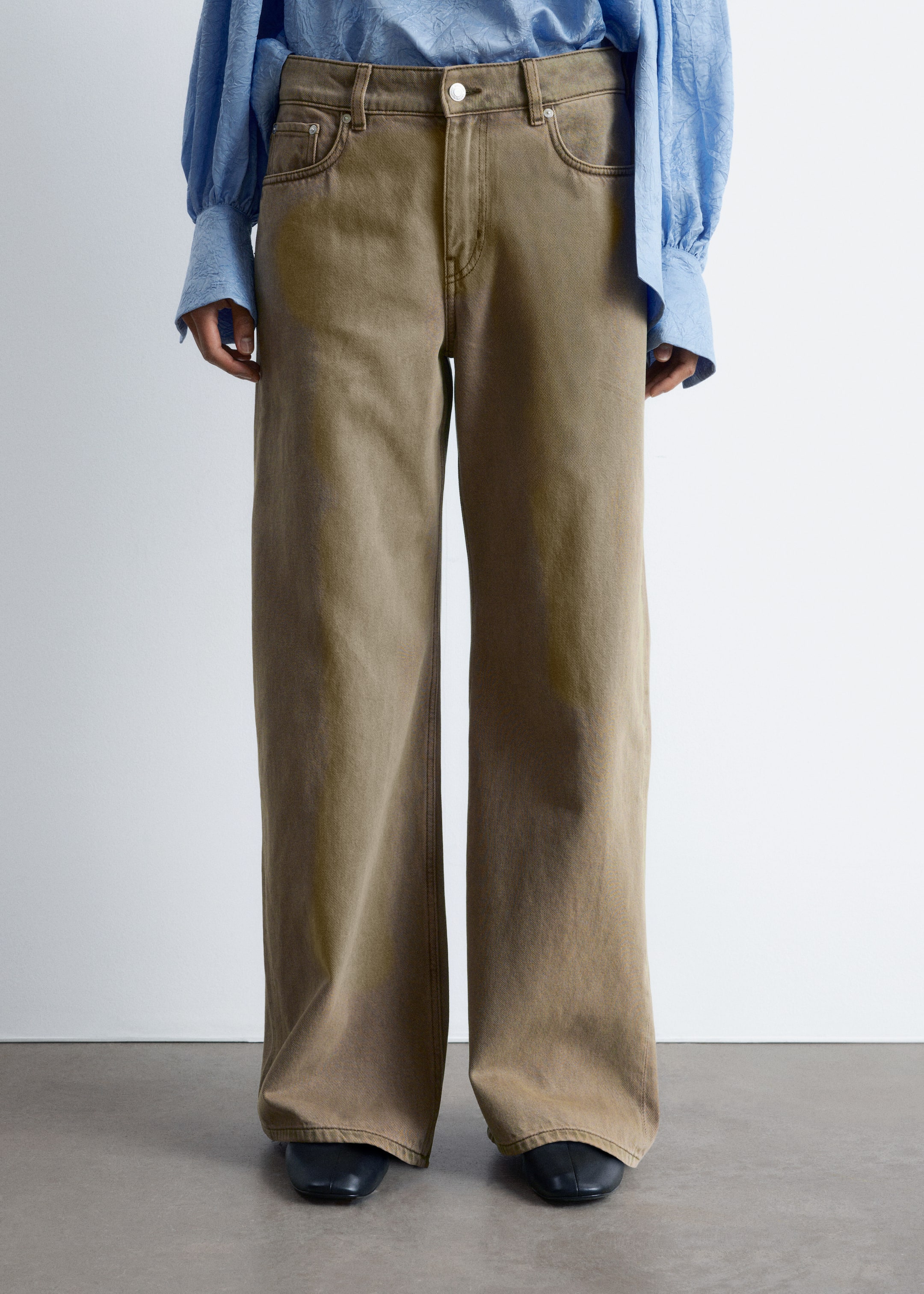 Visualizza immagine più grande: Pantaloni kaki a gamba larga lavati sono presentati frontali, con vita alta e chiusura con bottone e cerniera e tasche frontali a cucchiaio. Il design a lunghezza intera si estende sopra le scarpe nere.
