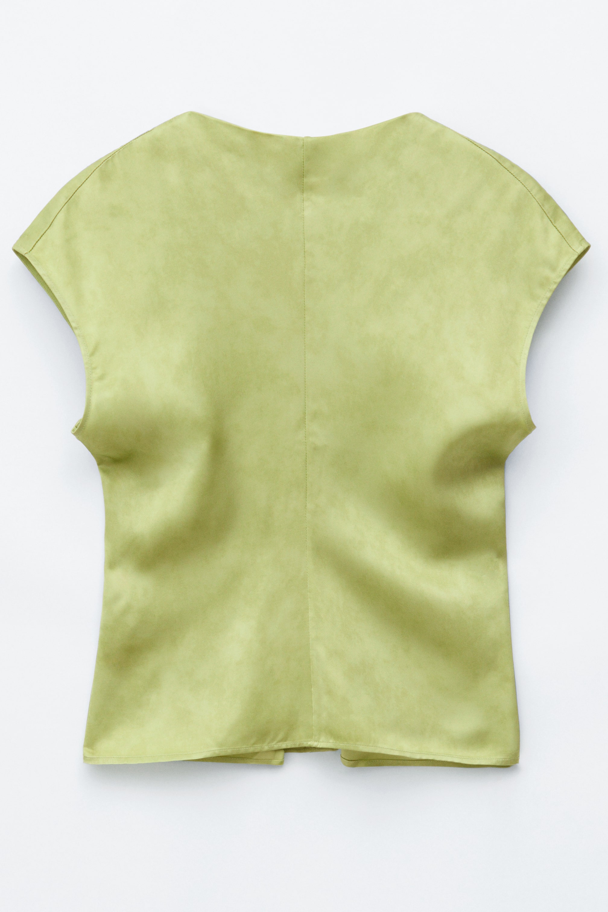 Zobraziť väčší obrázok: Svetlozelený bezrukávový top je zobrazený zozadu, s voľnými ramenami, jemne textúrovaným povrchom a vertikálnym švom, ktorý prechádza stredom chrbta a naznačuje zips.