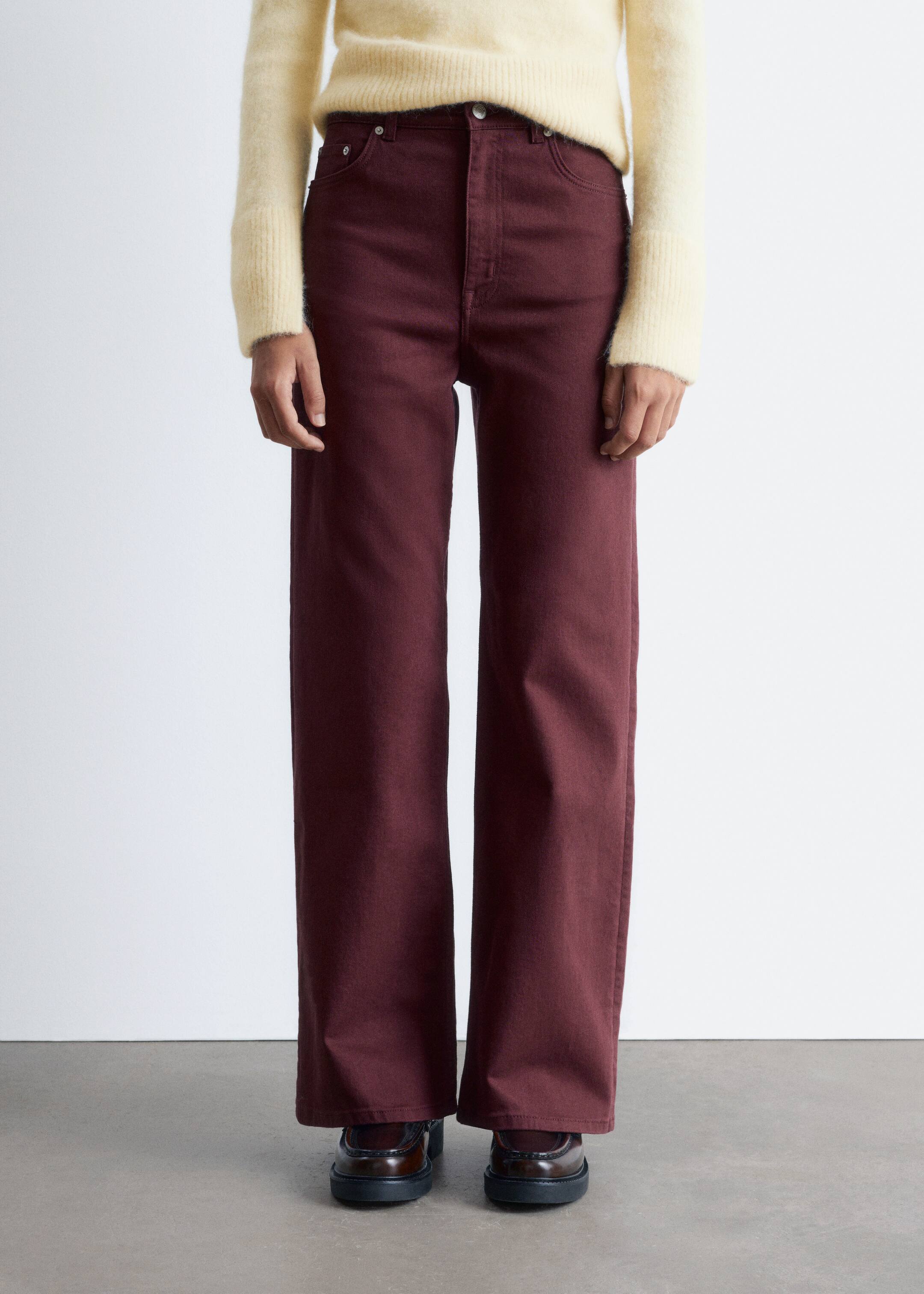 Ver imagen más grande: Pantalones anchos de color granate se presentan desde una vista frontal, con un ajuste de cintura alta, bolsillos frontales visibles y trabillas para el cinturón. Las piernas rectas y de largo completo se extienden hasta los tobillos, interactuando con un suéter de color crema que cubre parcialmente la cintura y zapatos de color marrón oscuro en el dobladillo.