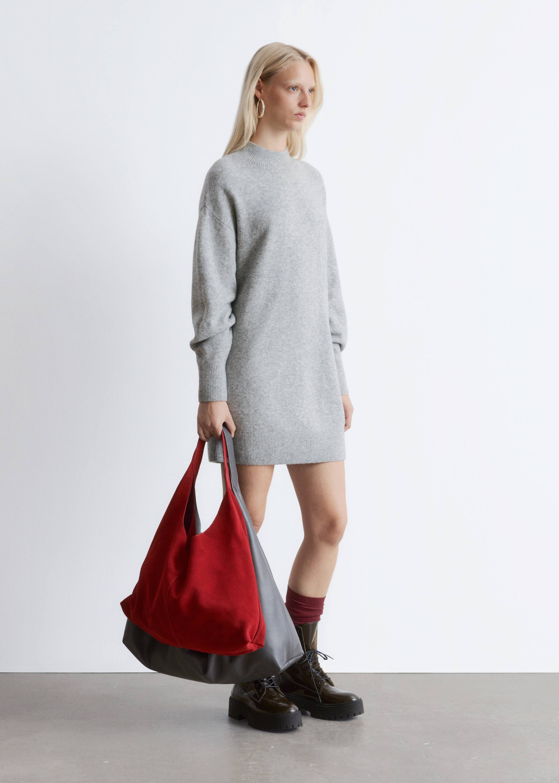 Größeres Bild anzeigen: Das hellgraue Strickkleid verfügt über einen Stehkragen und lange Ärmel mit gerippten Bündchen. Es präsentiert einen lockeren, geraden Schnitt, endet oberhalb des Knies und ist aus einem leicht seitlichen Winkel zu sehen.