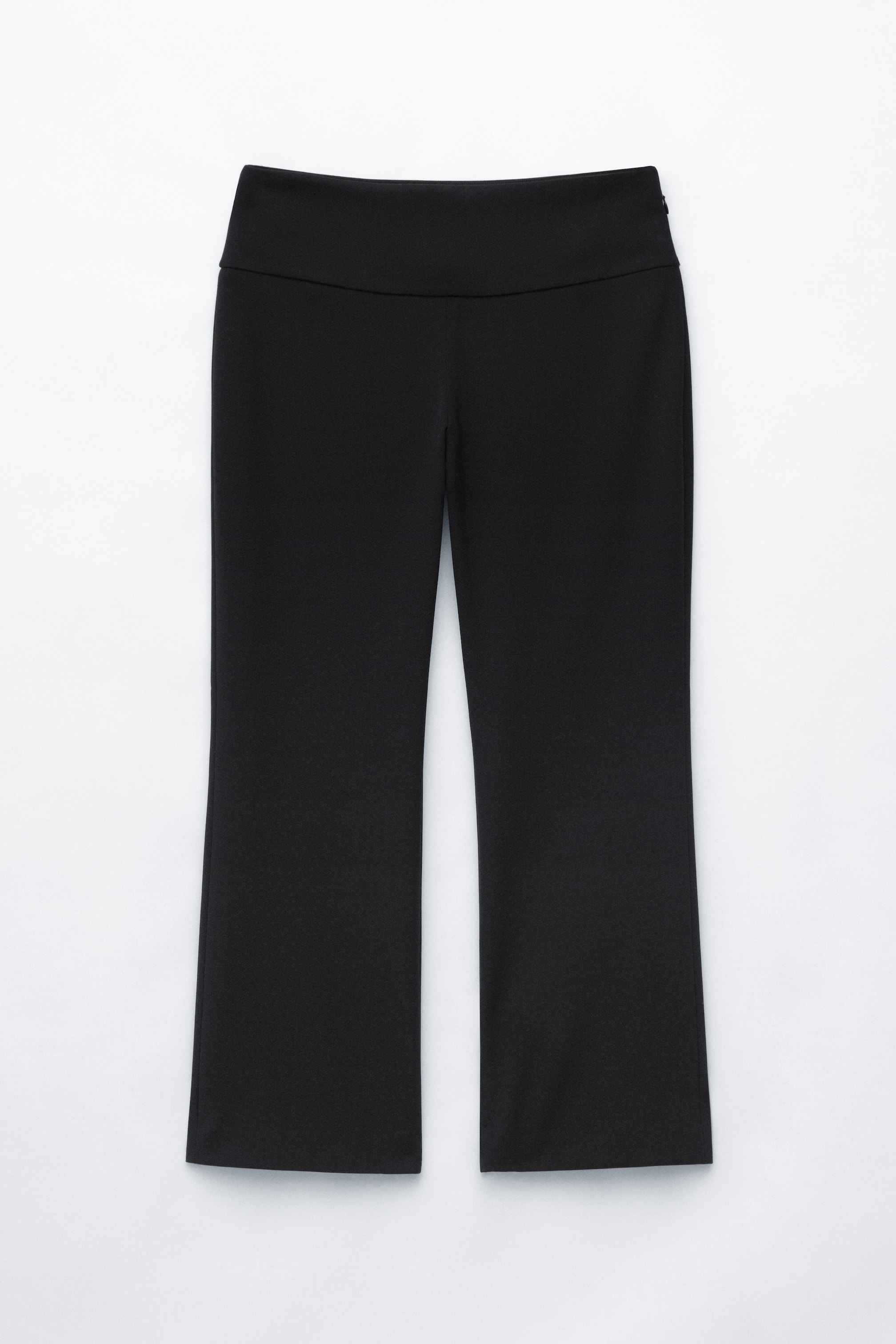 Ver imagen más grande: Los pantalones negros presentan una cintura ancha y plana y una silueta de corte bootcut, con las piernas acampanándose suavemente desde la rodilla.