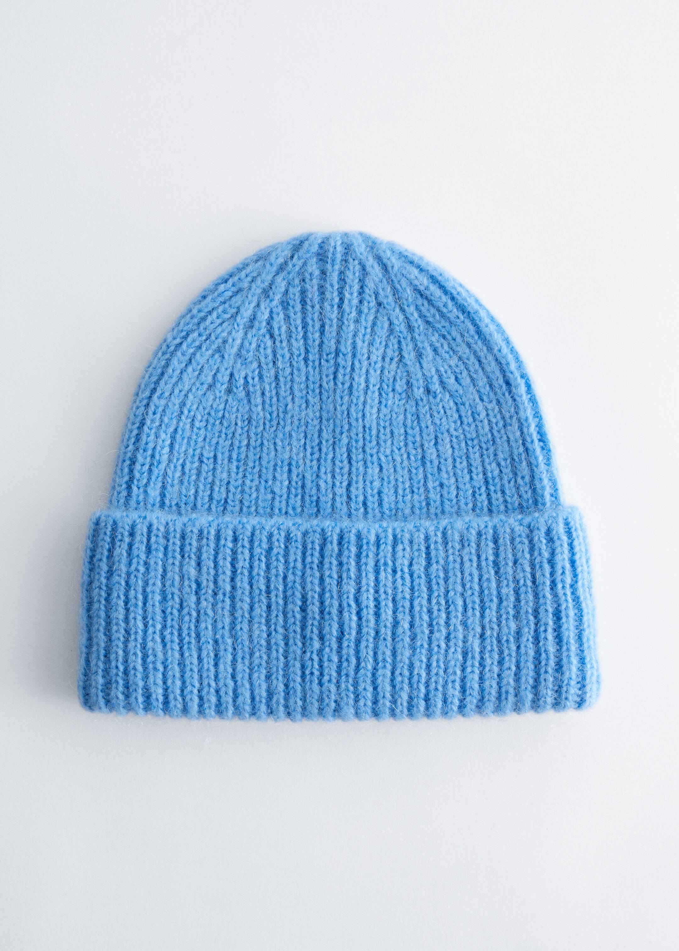 Größeres Bild anzeigen: Eine hellblaue Mütze wird von vorne präsentiert. Sie zeichnet sich durch eine weiche, leicht flauschige Textur und einen breiten, umgeschlagenen Rand mit einem sichtbaren Rippstrickmuster aus.