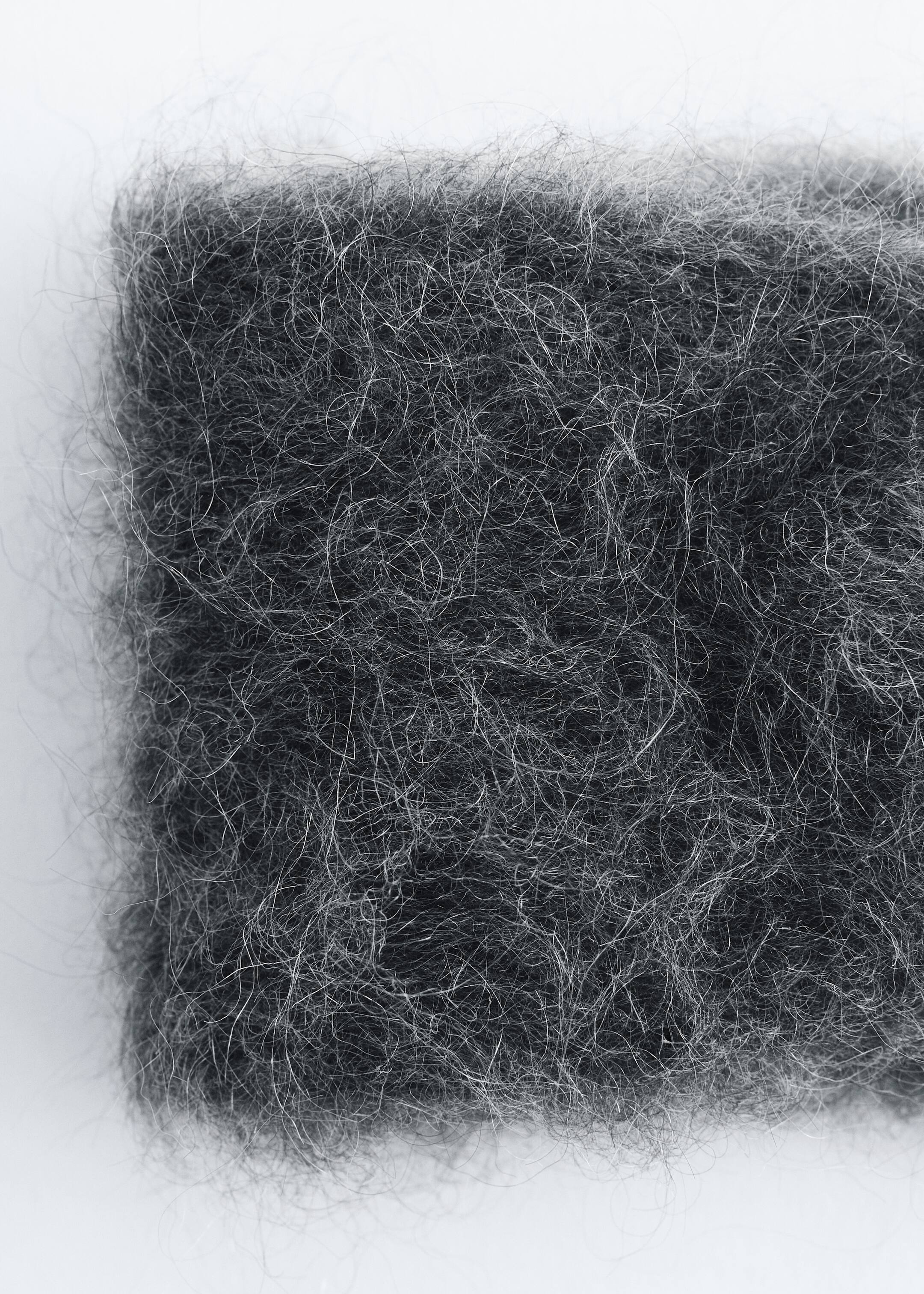 View larger image: Mohair-Blend Twist-Front Headband: The dark gray, fuzzy material of the headband is being shown in an extreme close-up. Fine, light-colored fibers are visibly intertwining with darker fibers, creating a soft, textured appearance.