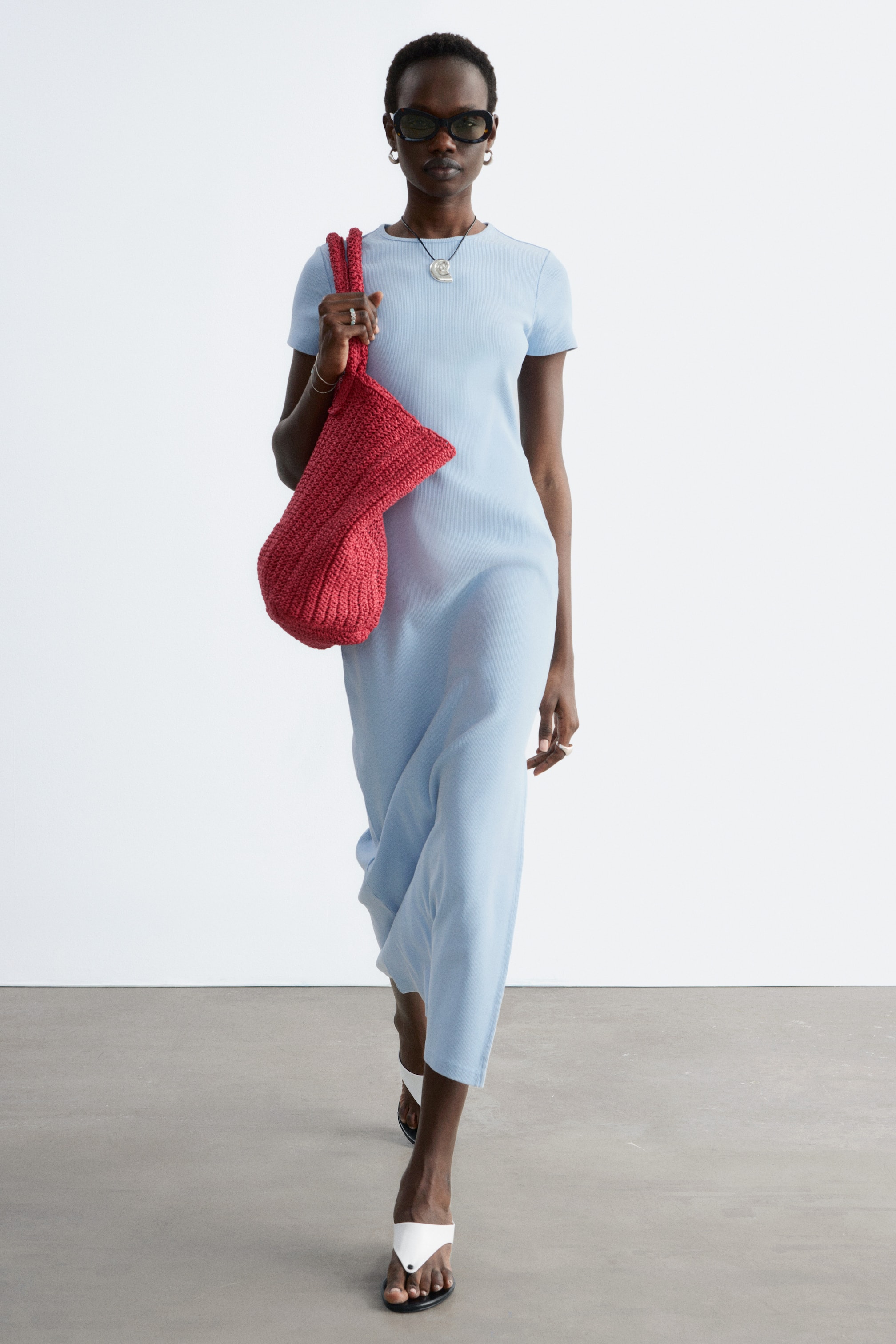 Visa större bild: En ljusblå midiklänning med rund hals och korta ärmar. Dess flödande tyg når en midilängd och presenteras från en framåtvänd vinkel.