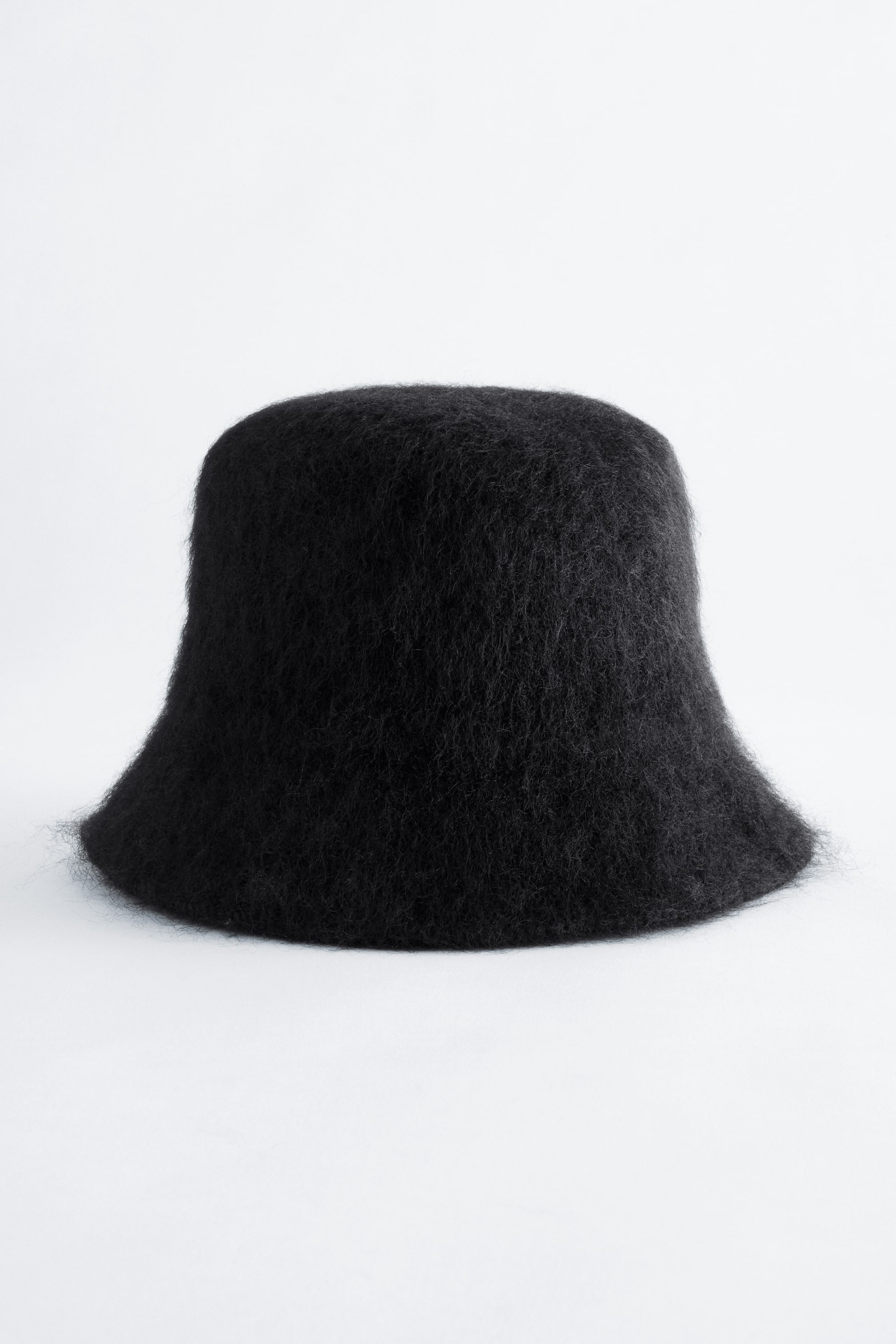 Se større billede: En sort bucket hat med en blød, fluffy børstet tekstur vises forfra og fremhæver dens strukturerede krone og korte, lige skygge.
