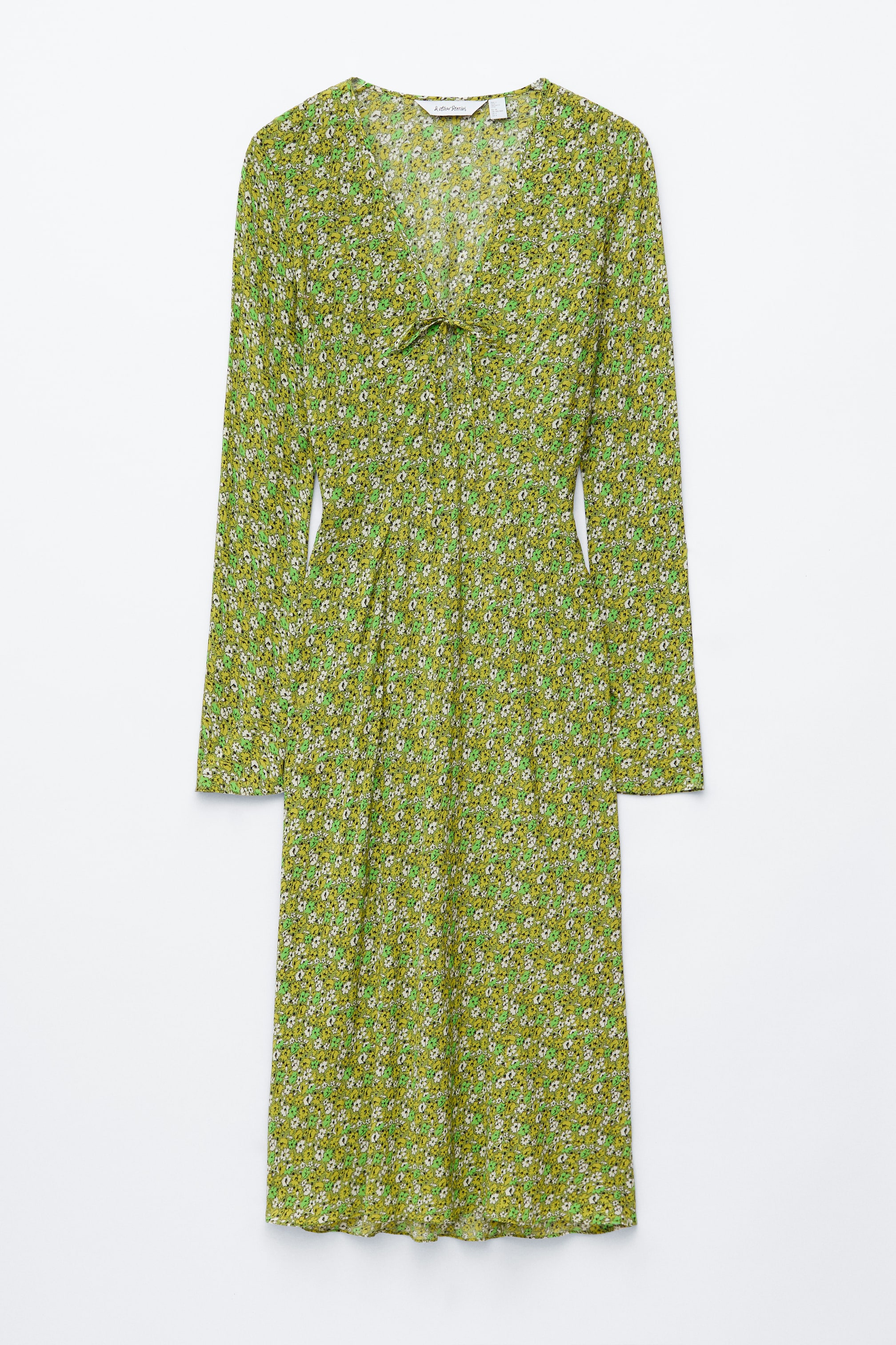 Ver imagem maior: Uma VISTA FRONTAL de um vestido midi verde exibe um padrão floral pequeno em branco e verde claro. Apresenta um decote em V com detalhe de laço na parte central da frente e mangas compridas.