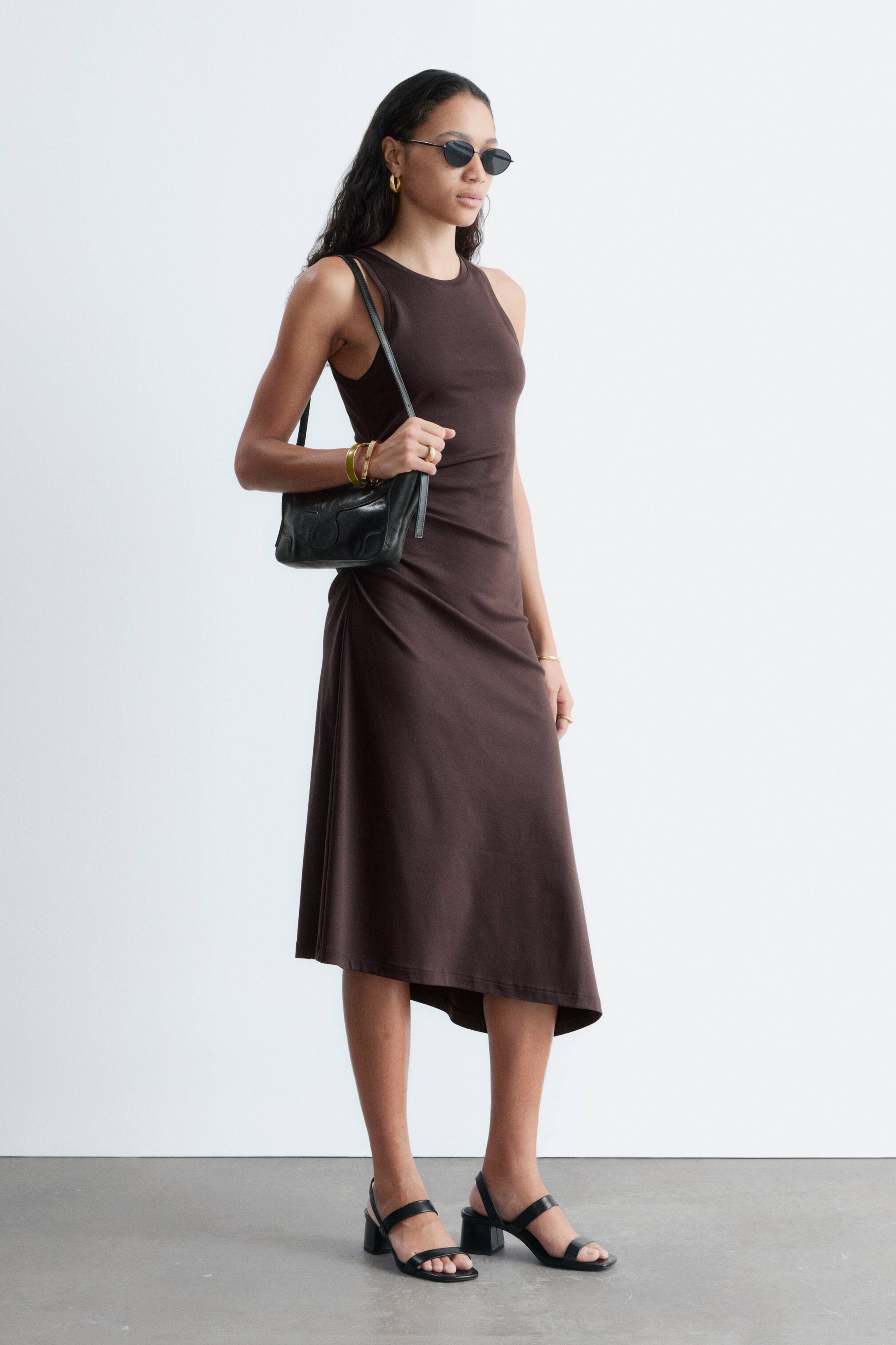 Zobraziť väčší obrázok: Čierne sandále s blokovým podpätkom z nappa kože majú remienkový dizajn a elastický zadný remienok. Modelka má na sebe tieto sandále.