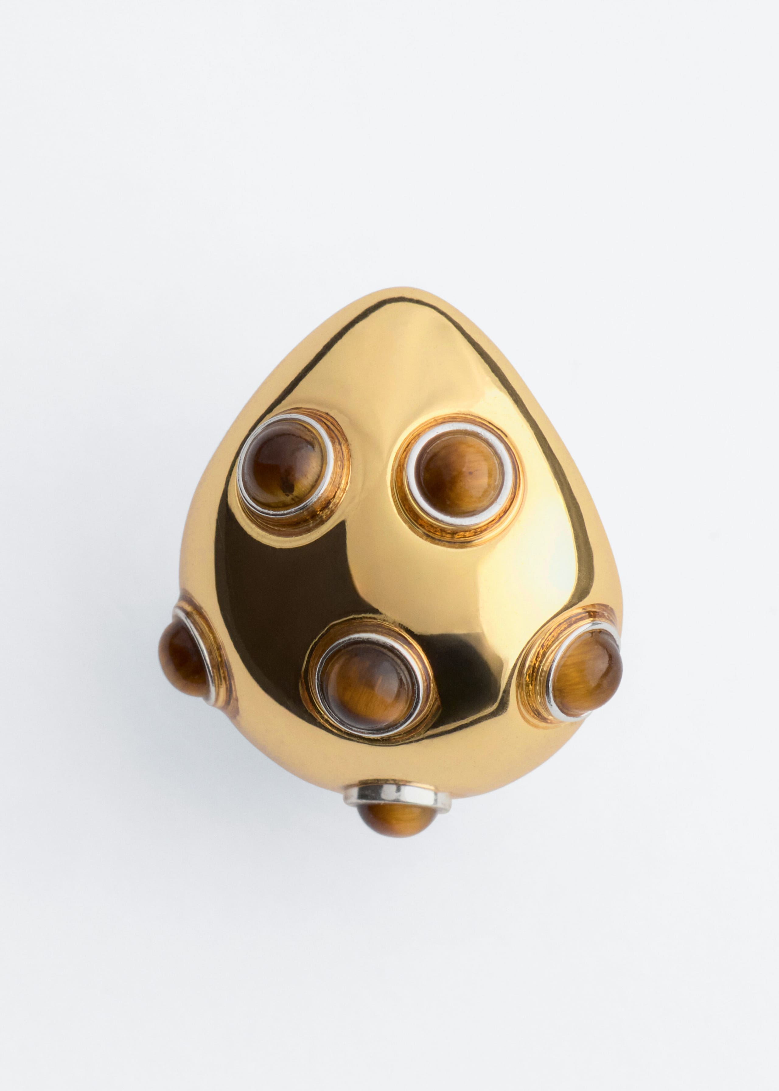 Un orecchino in ottone lucido dalla forma morbida e arrotondata, simile a una goccia, è ripreso frontalmente, con più pietre di occhio di tigre cabochon rotonde incastonate in castoni rialzati sulla superficie riflettente color oro.